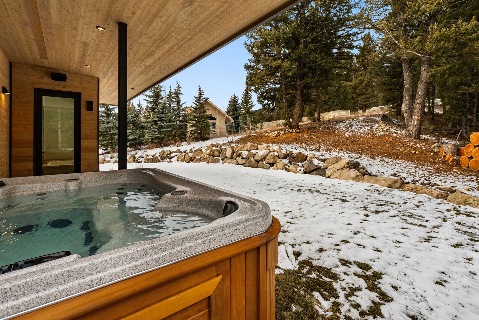 Soak in your private hot tub while snow dusts the evergreen landscape around you.