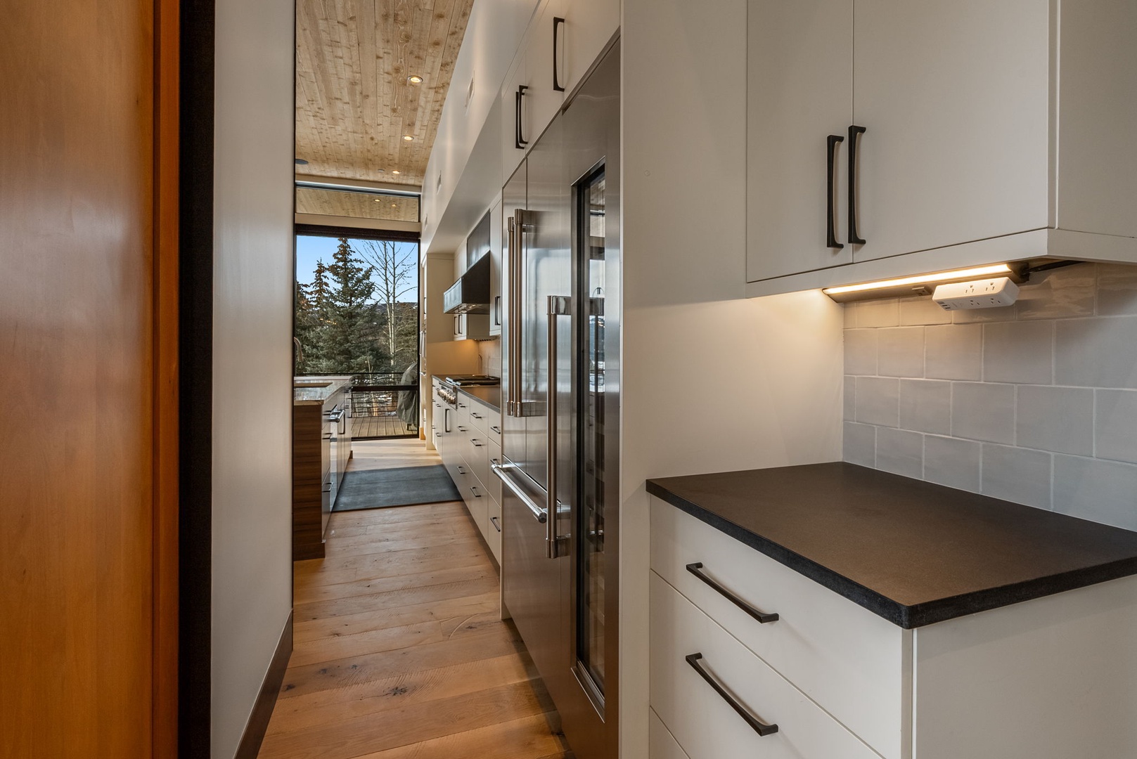 Your sleek modern kitchen awaits with premium appliances and stunning mountain views through expansive windows.