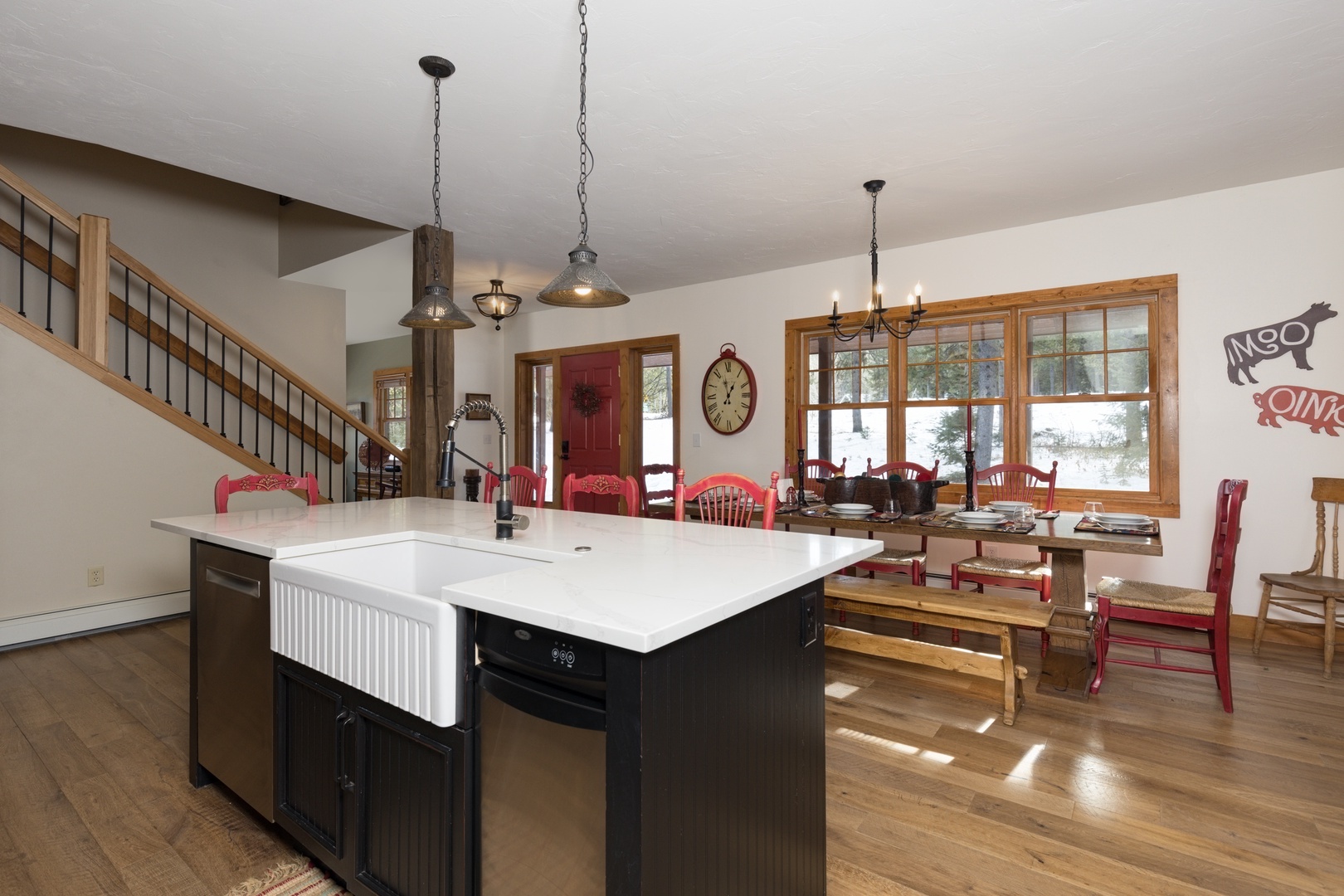 Your spacious kitchen island becomes the heart of memorable meals, while red dining chairs add warmth to gatherings.