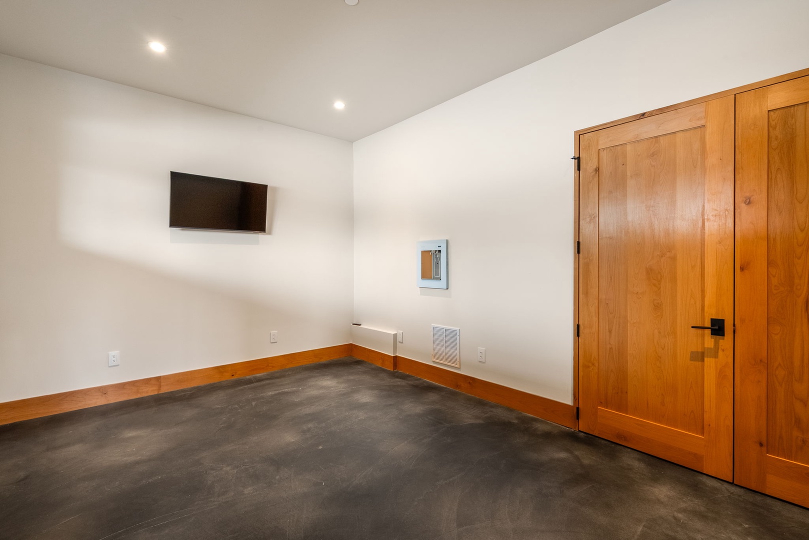 Unwind in your private media room with wall-mounted TV and warm wood accents creating the perfect atmosphere for movie nights.