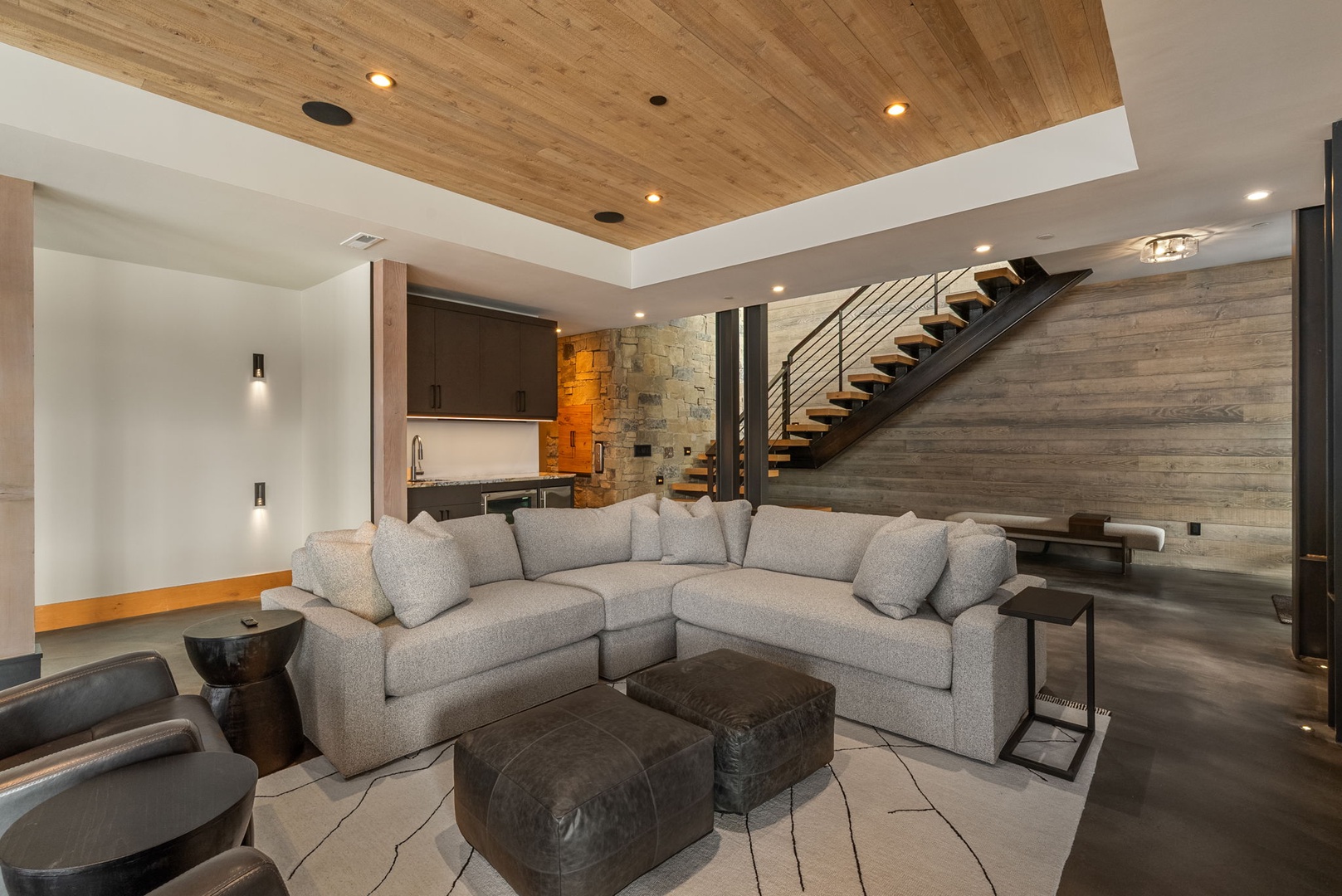 Unwind in your contemporary living space, where soaring wood ceilings and a luxurious sectional create the perfect retreat.