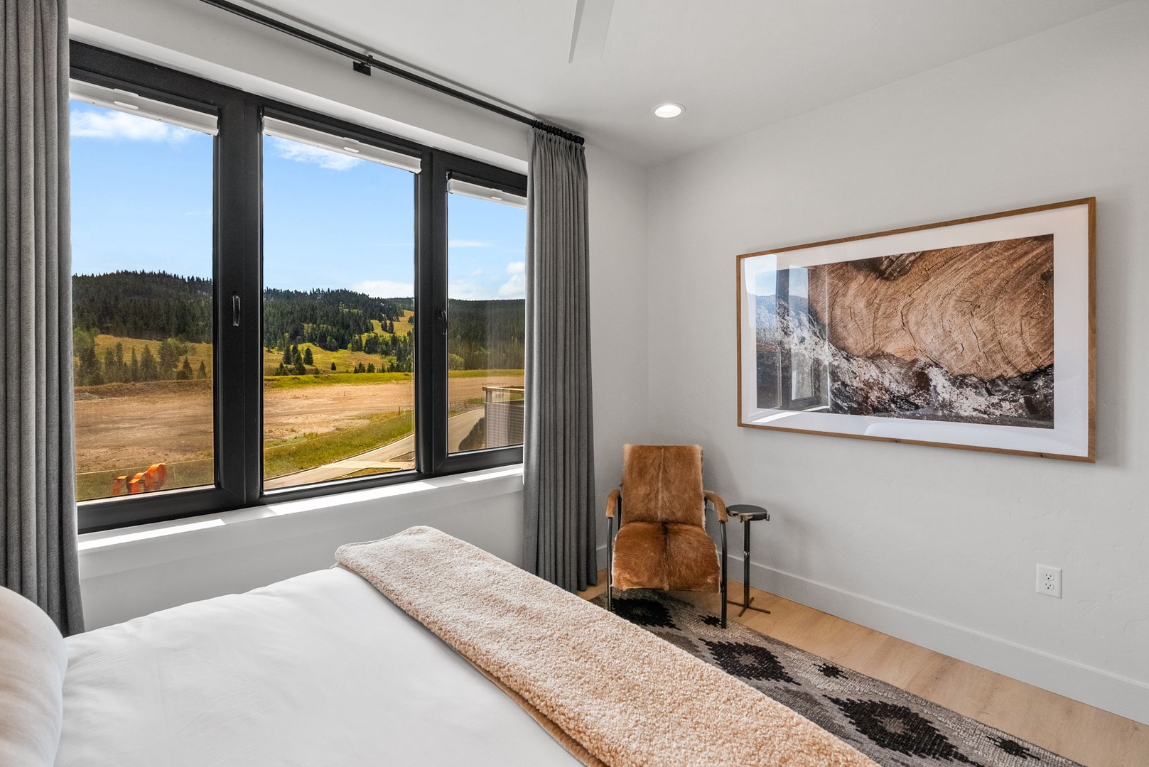 Wake up to sweeping mountain and meadow views framed by oversized windows, where natural beauty greets you each morning in your serene retreat.
