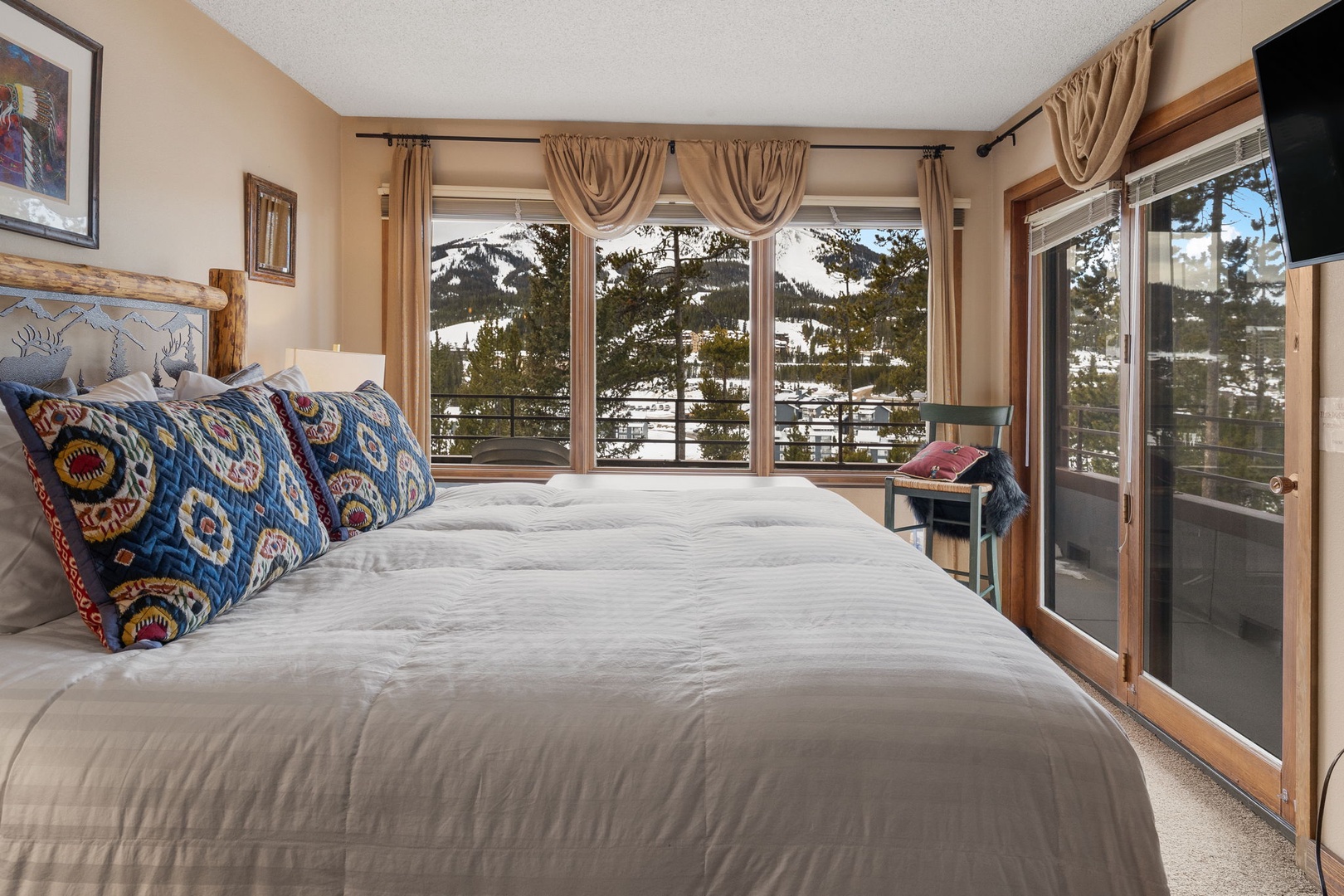 Wake up to breathtaking snow-capped mountain views from your cozy bedroom. Large windows frame the alpine scenery perfectly.