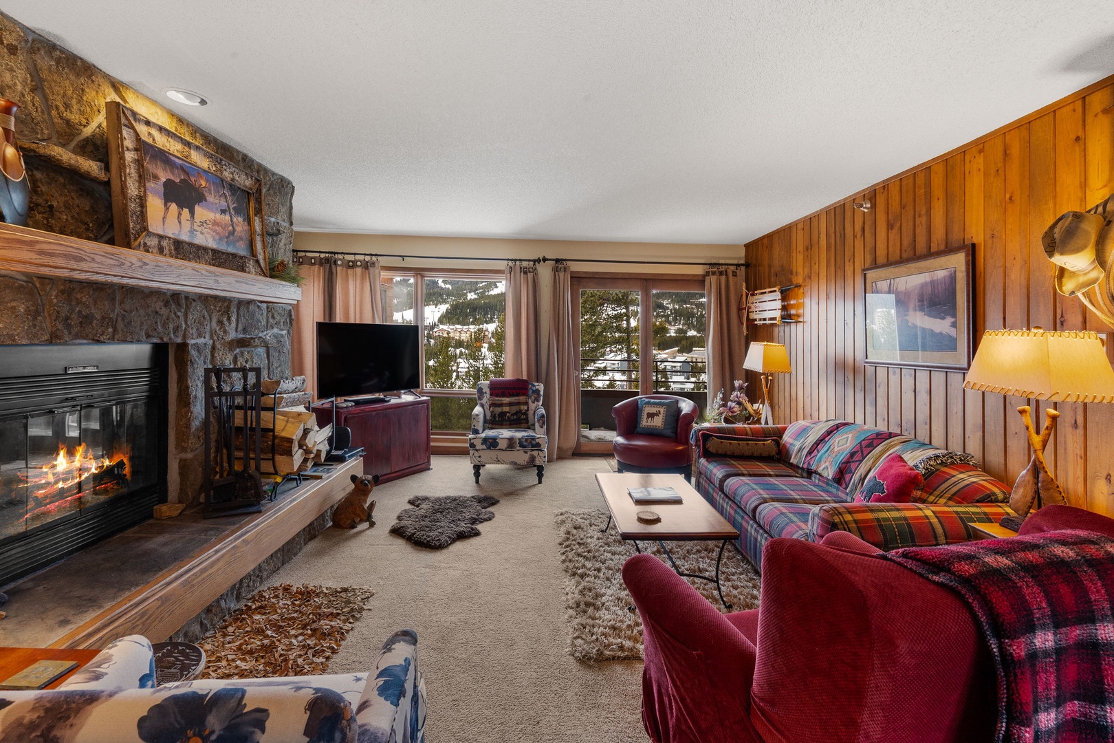 Cozy up by your crackling stone fireplace surrounded by warm wood paneling and colorful mountain charm.