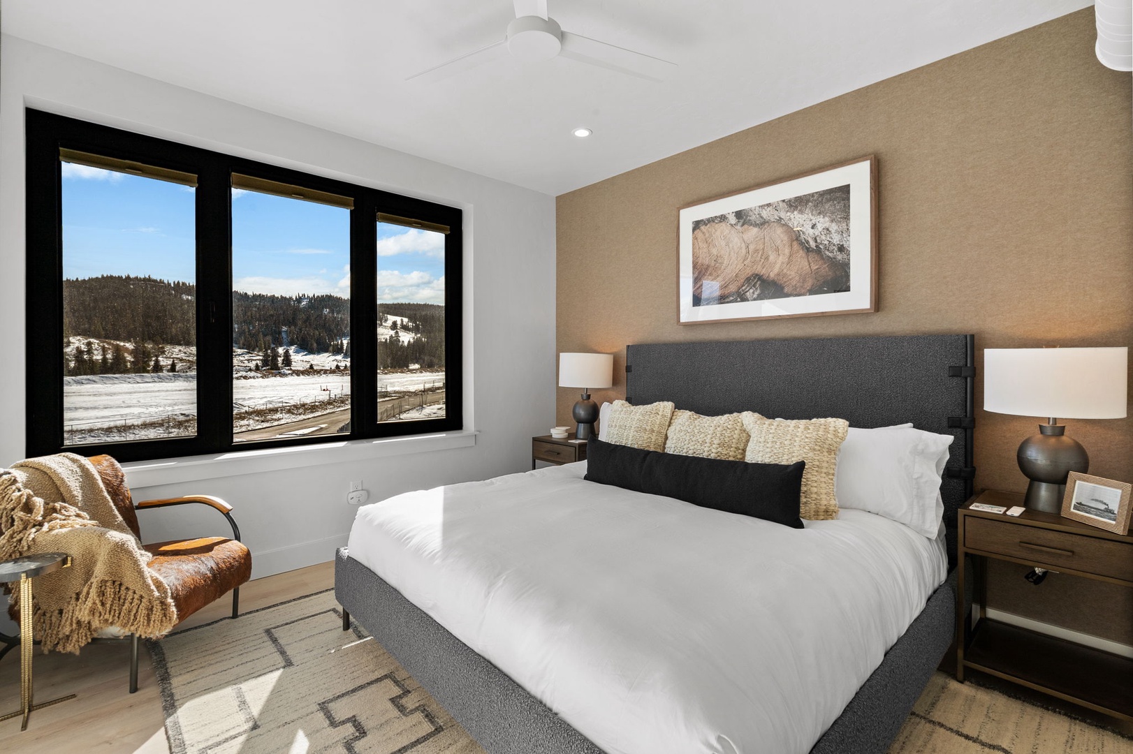 Your serene bedroom sanctuary features a plush king bed and stunning mountain views through floor-to-ceiling windows.