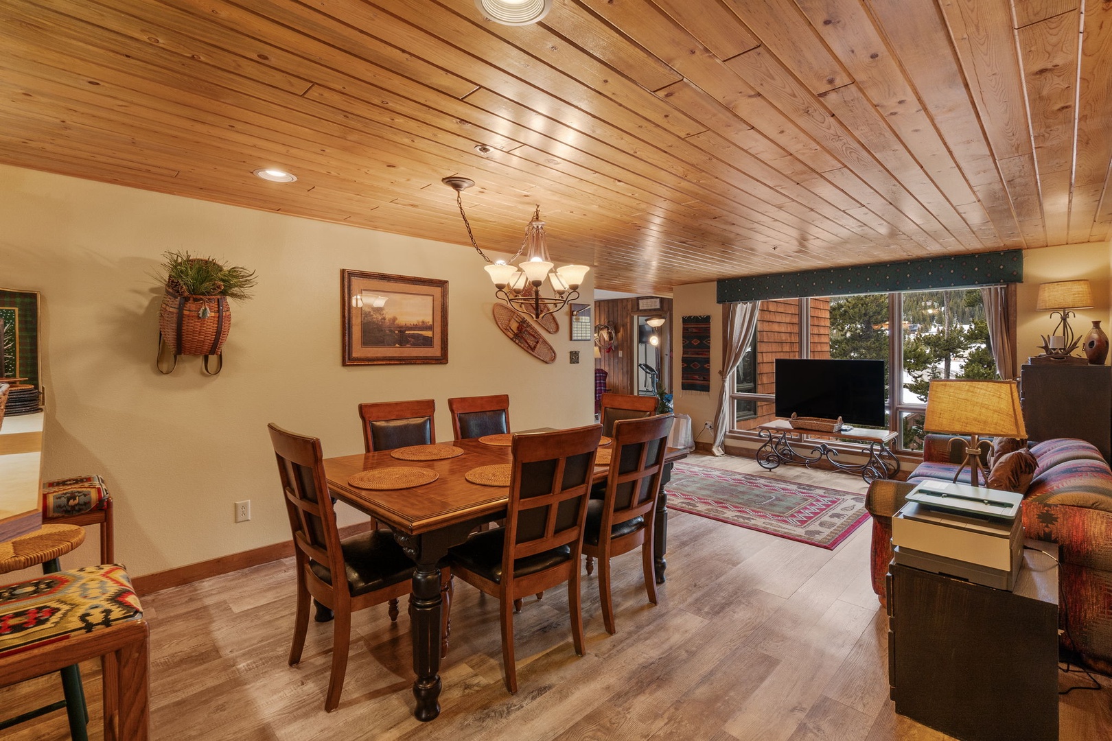 Gather around your dining table beneath warm wood ceilings, where rustic charm meets modern comfort in this inviting space.
