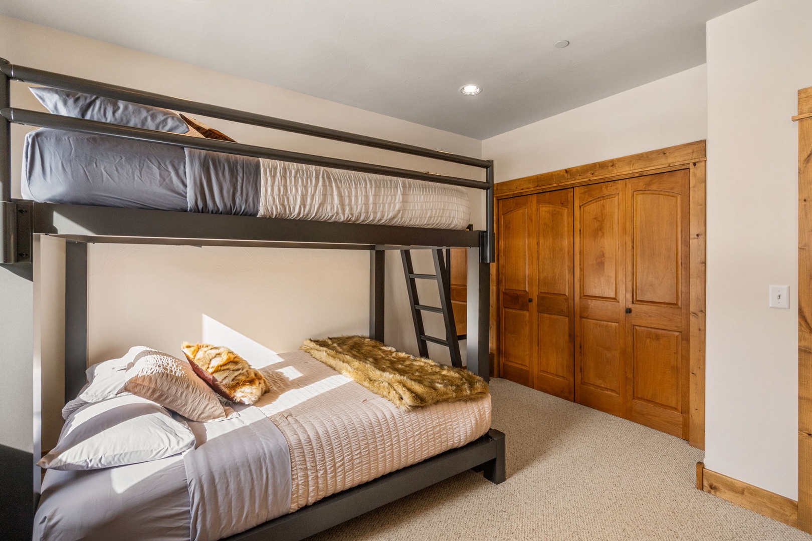 Rest easy in this cozy bunk room where soft linens and warm wood create your perfect mountain retreat.