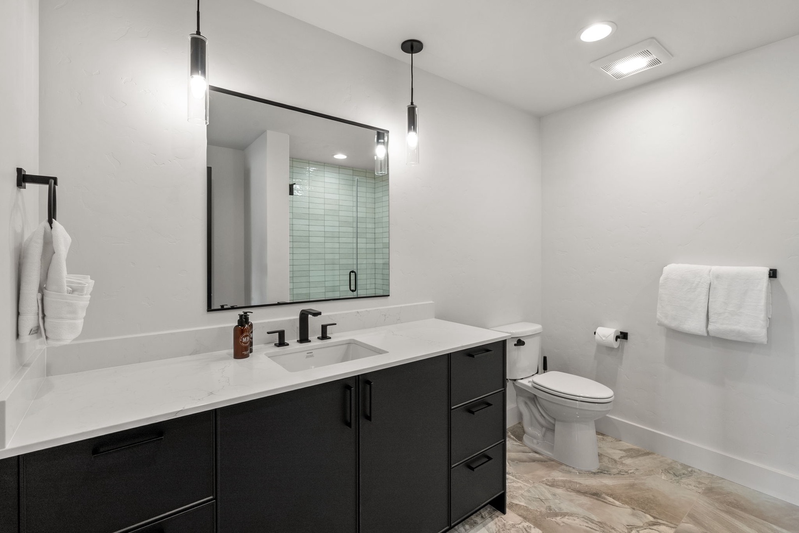 Step into your modern, spa-like bathroom with sleek finishes, a spacious vanity, and fresh towels waiting for you. The walk-in shower and thoughtful design make every moment feel effortlessly luxurious.
