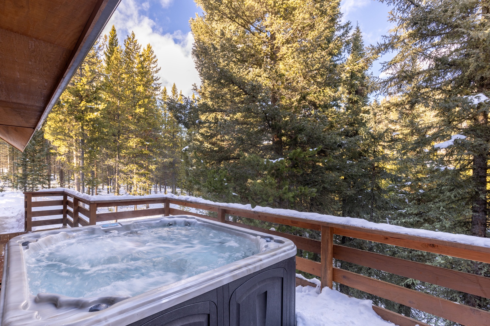 Soak in your private hot tub surrounded by snow-dusted evergreens, where winter's tranquil beauty creates the perfect backdrop for relaxation.