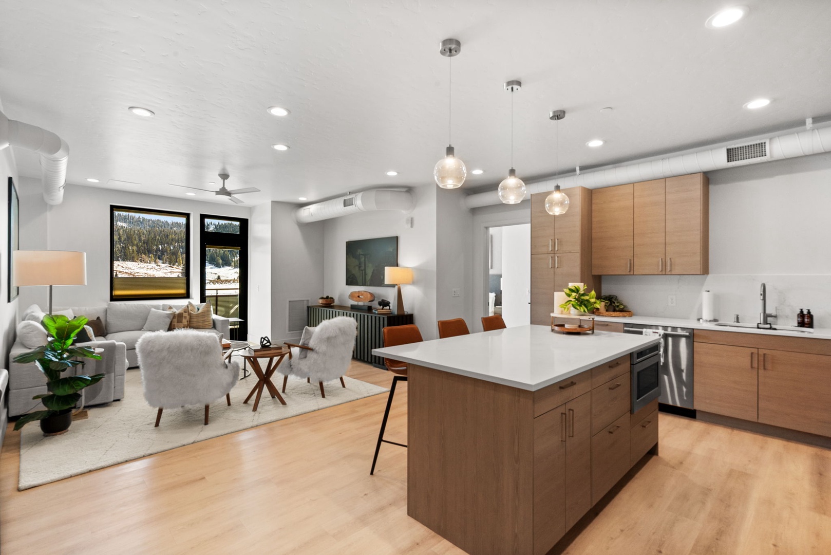 Your modern open-concept retreat blends warm wood tones with sleek surfaces, creating an inviting space where you can cook, dine, and relax.