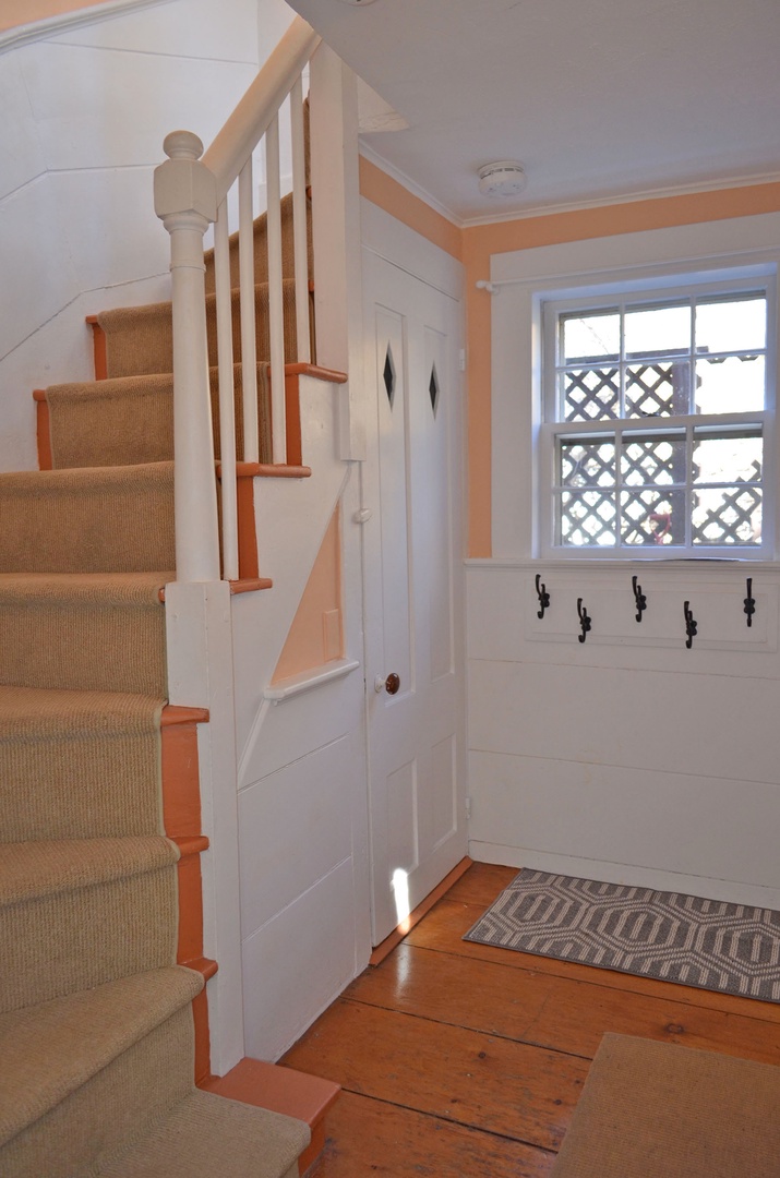 The staircase to the second level. Hooks for coats or bags.