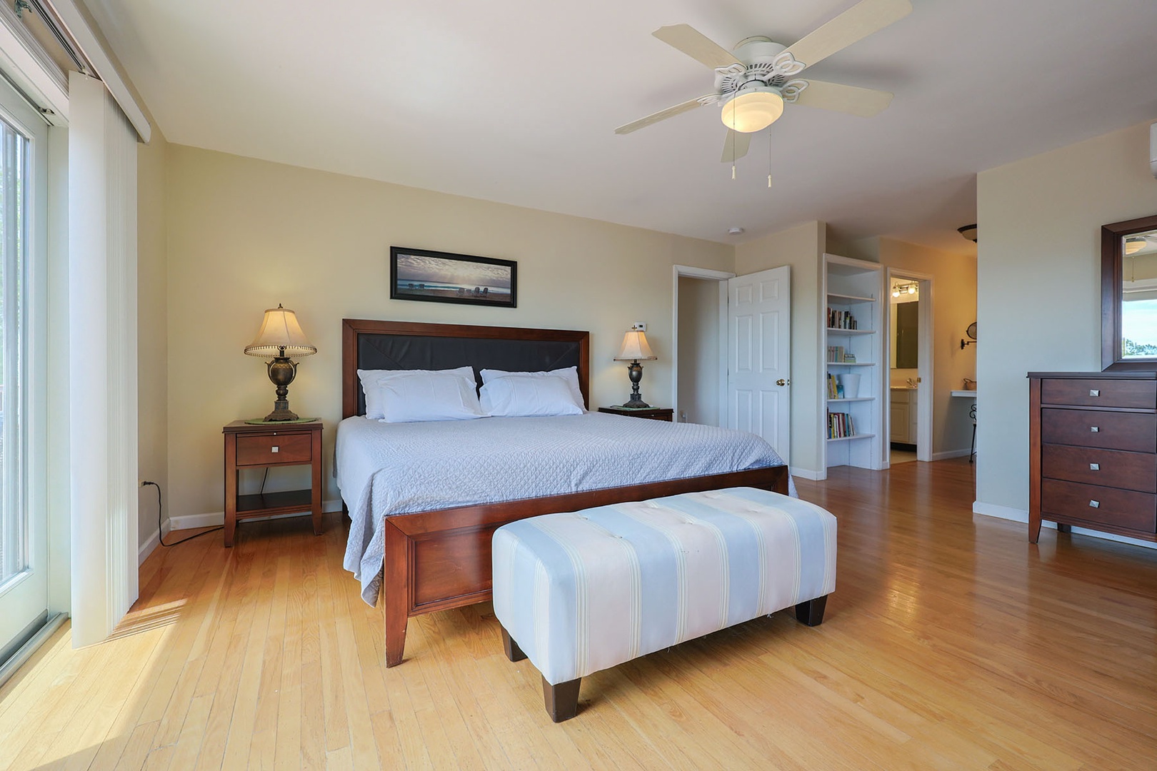 The spacious primary bedroom includes a bookshelf with books