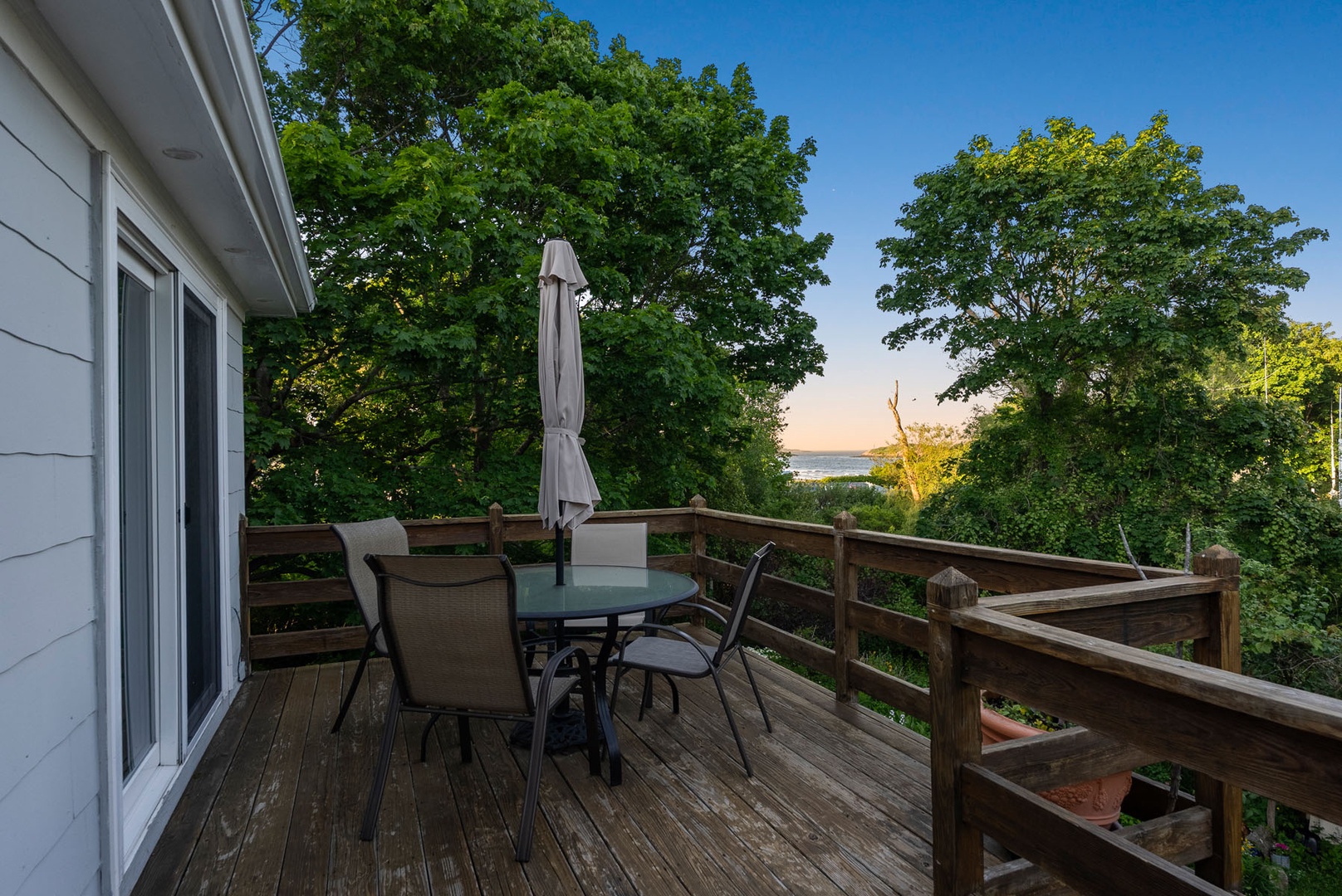 The deck has a dining table with an umbrella.