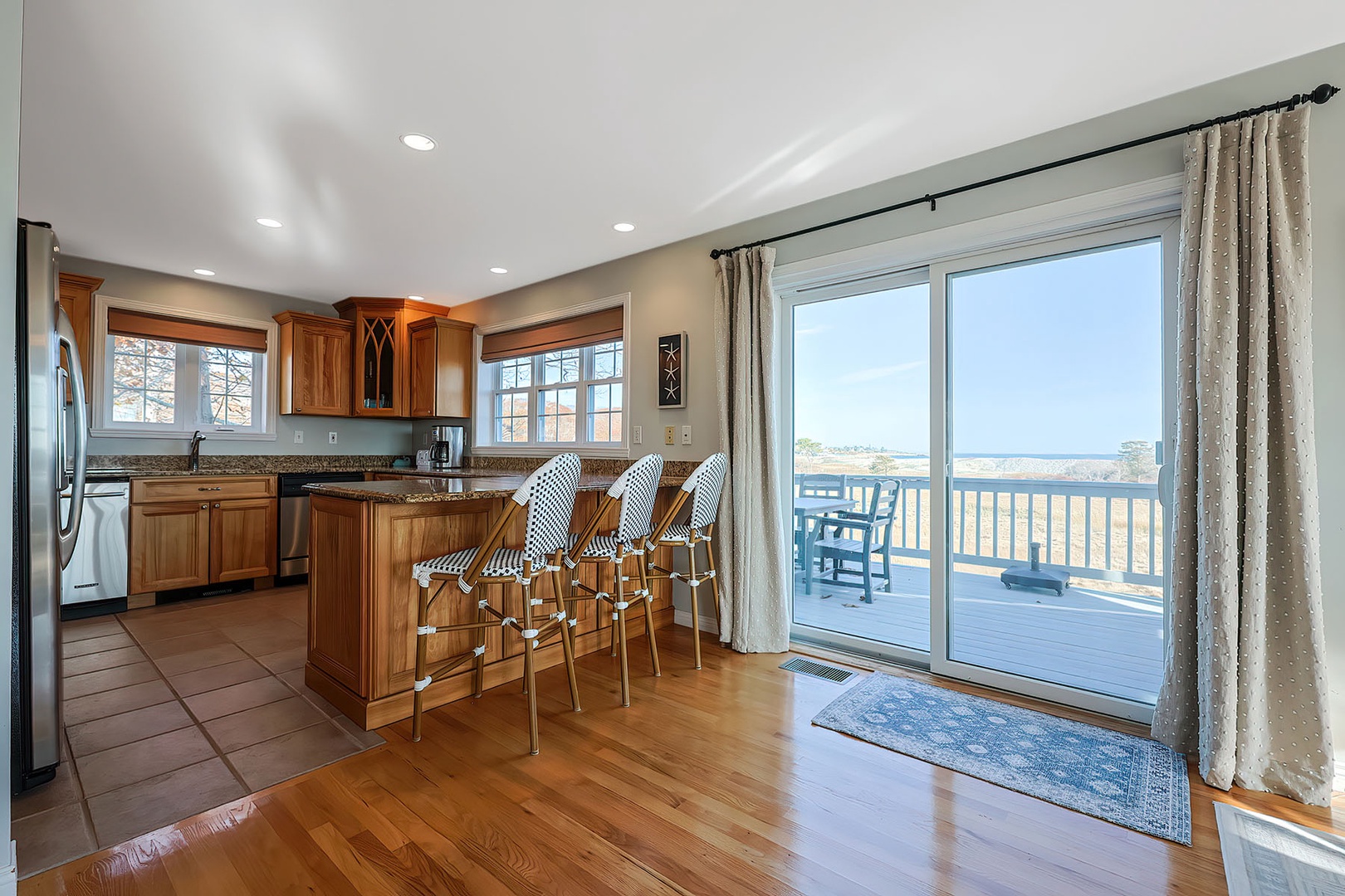 Modern kitchen adjacent to dining area and deck.