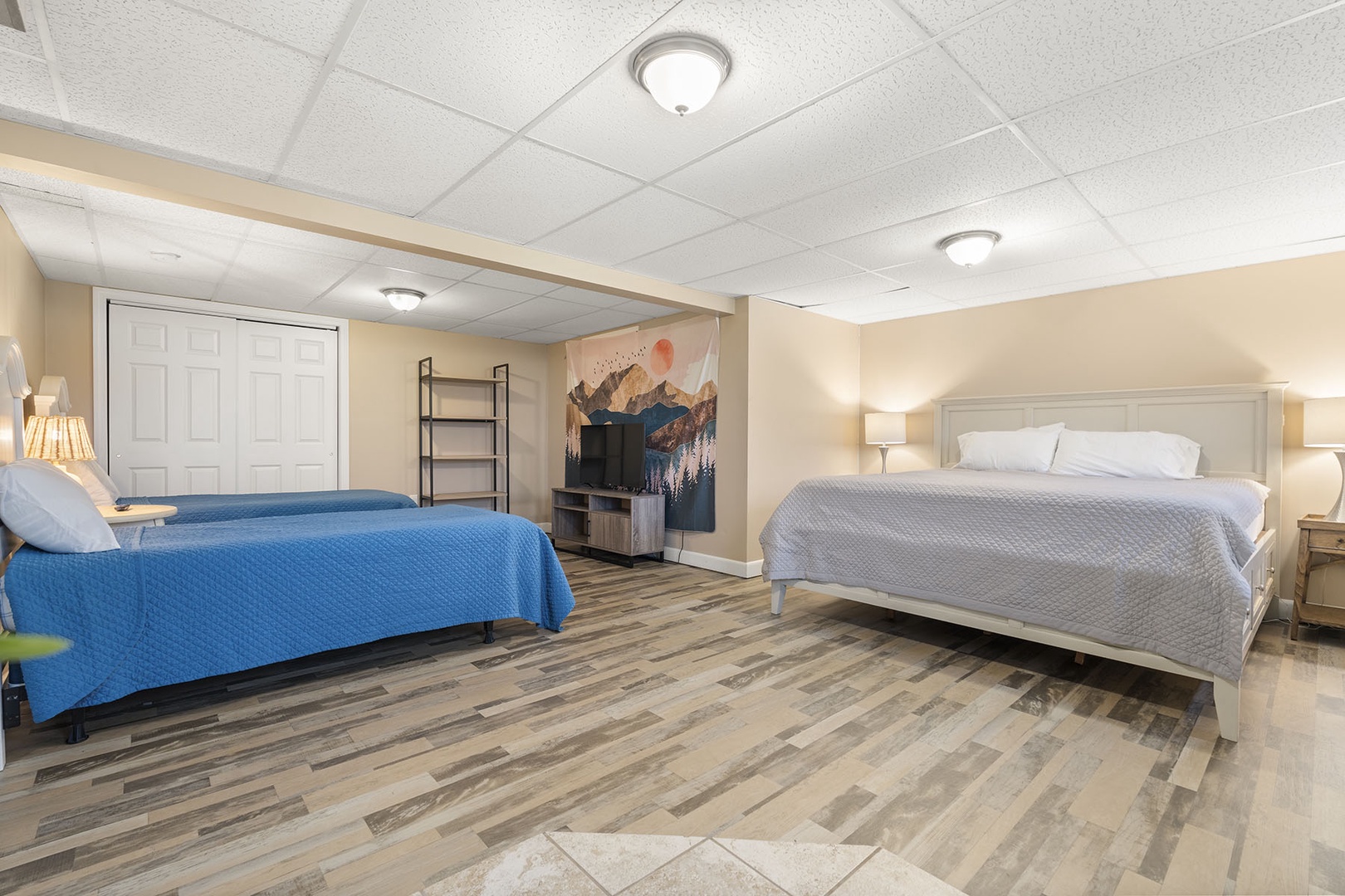 Lower floor bedroom with 1 King Bed, 2 Twin Beds and a TV.