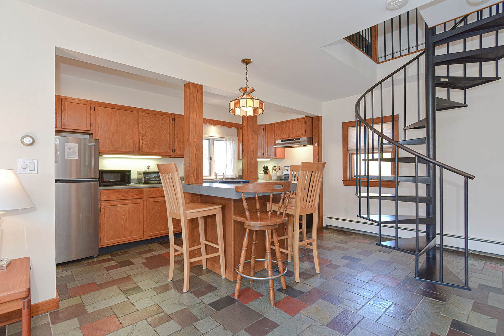 Kitchen and dining area. Spiral stairs lead to the second floor Primary suite.