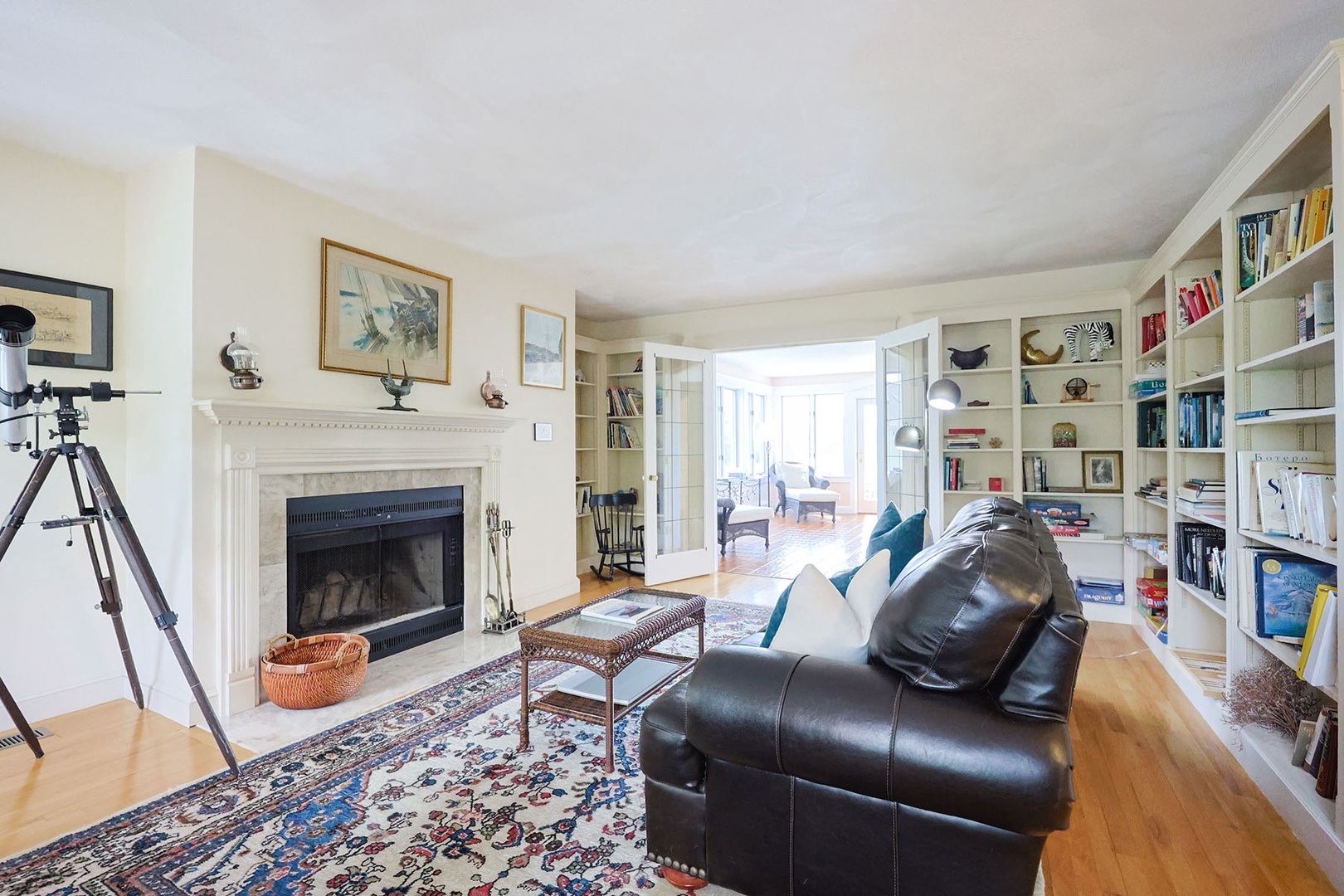 Living Room 2: Leather sofas, fireplace and built-in shelves with books.