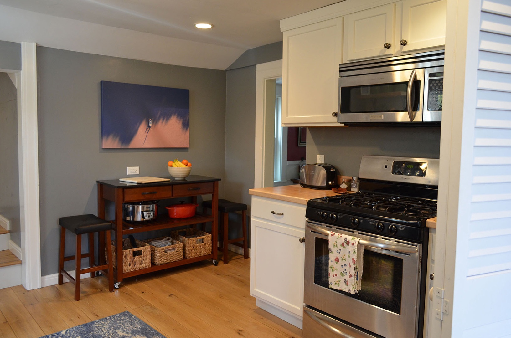The kitchen has a stainless steel gas stove and microwave.