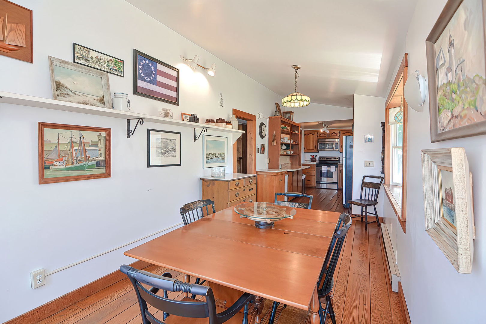 The dining table is at the other end of the kitchen.