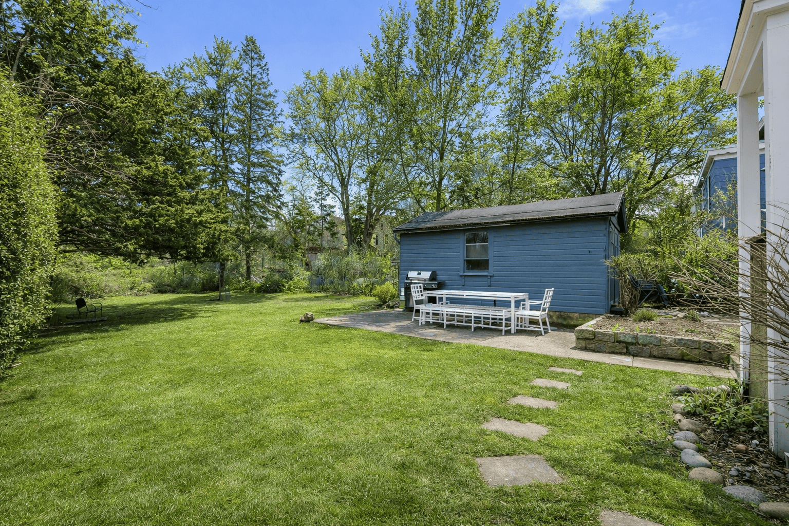 The lush backyard offers privacy and calm, there's an outdoor shower as well.