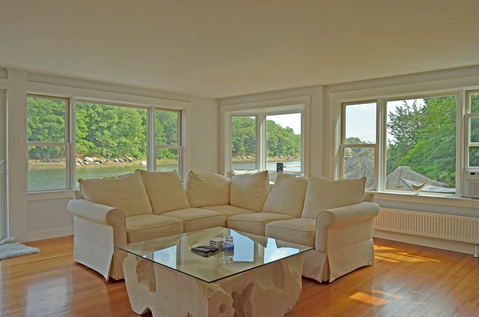 The living area features a cozy sectional sofa and river views.