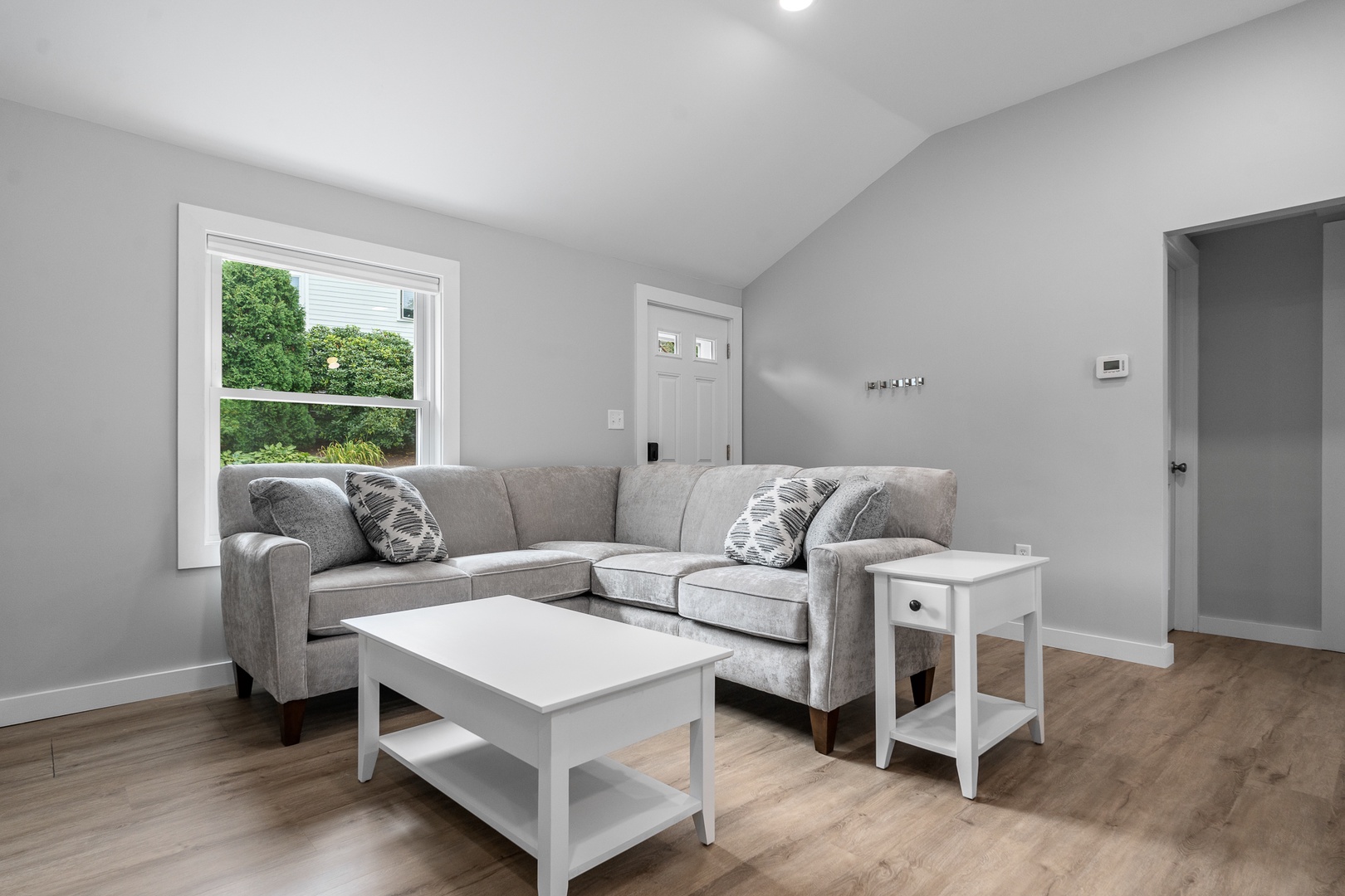 Living room has plenty of natural light and green views out the window.
