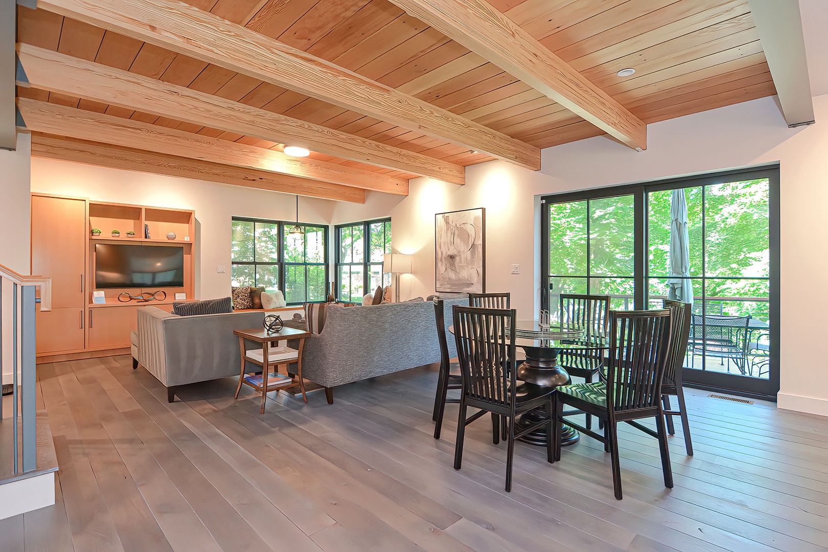 The dining area with glass sliding doors lead out to a contemporary deck.