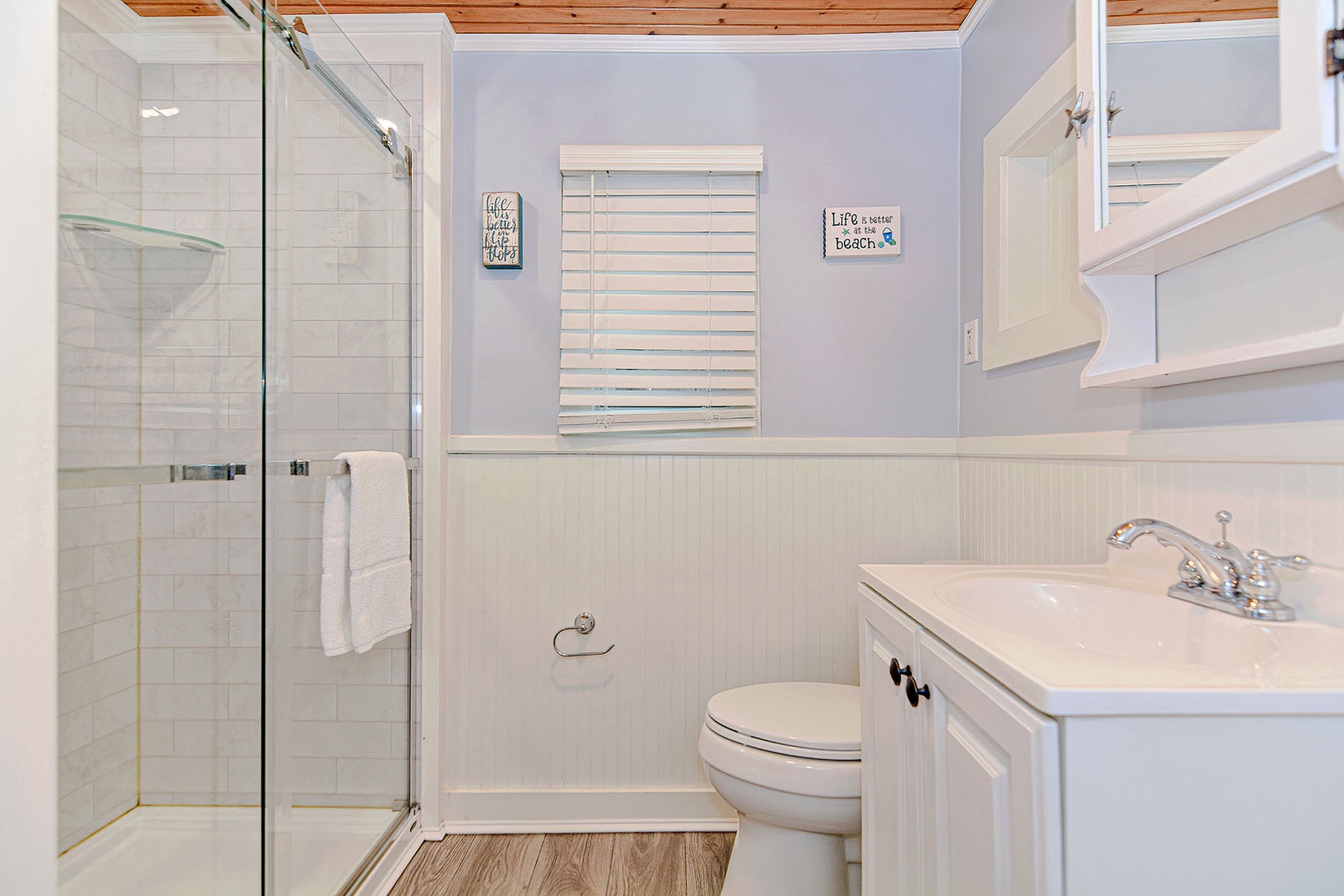 Main level full bath with walk-in shower and laundry unit.