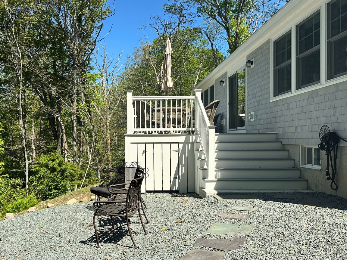 Back deck with umbrella, table, and chairs.