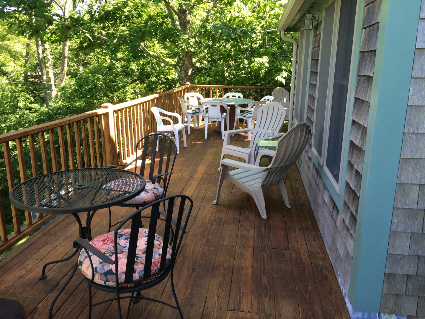 Elevated back deck with dining area and gas grill.