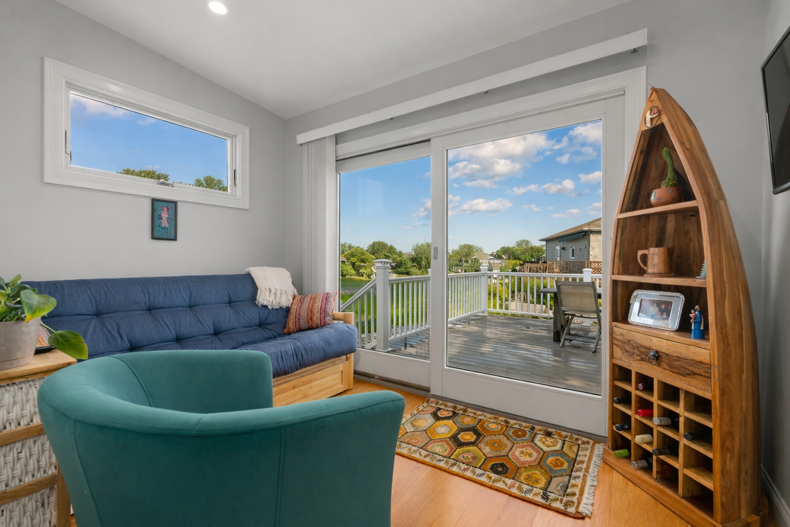 Cozy den with a futon, TV, and sliding door to the outdoor deck.