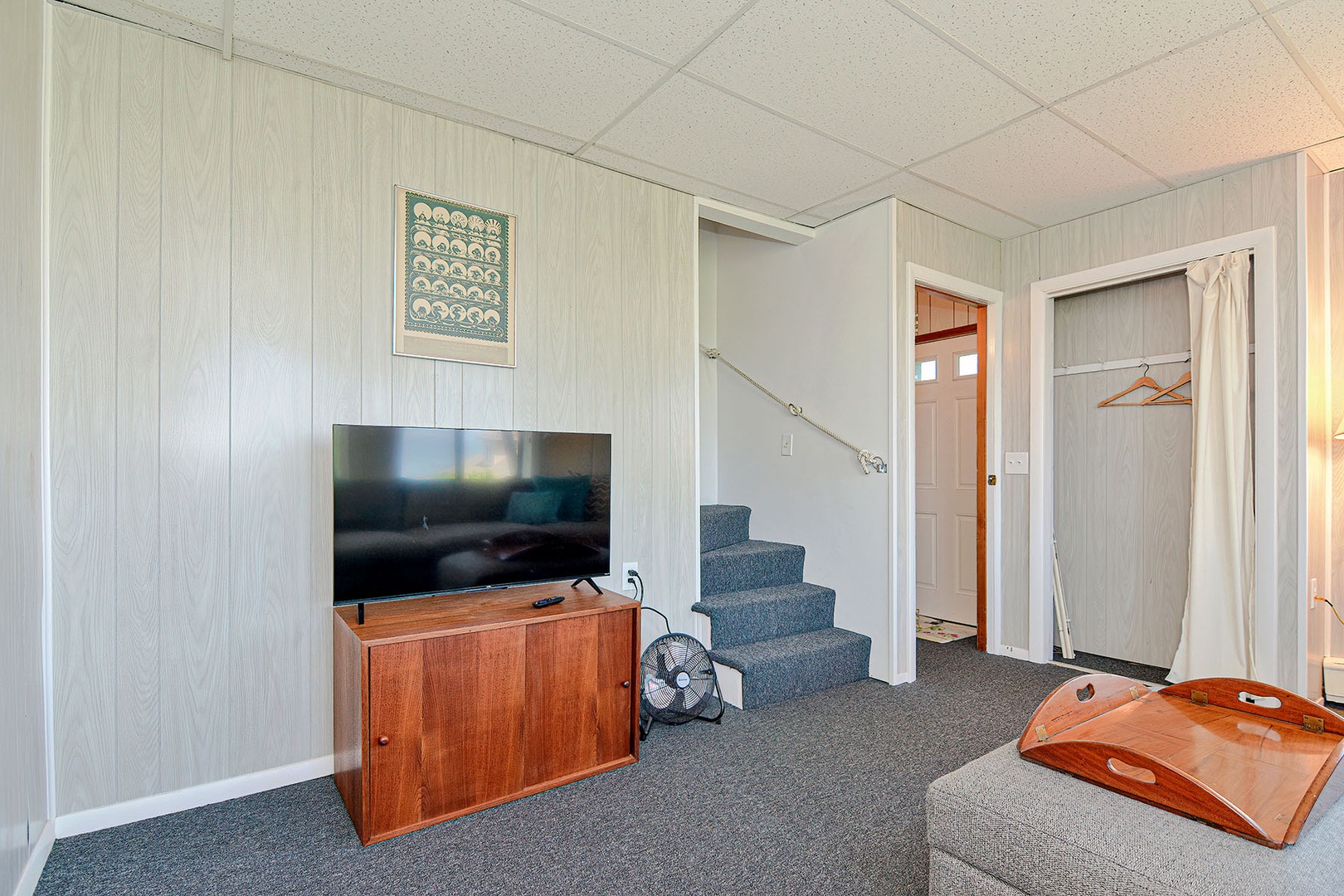 Downstairs/garden level with sofa, TV and water view