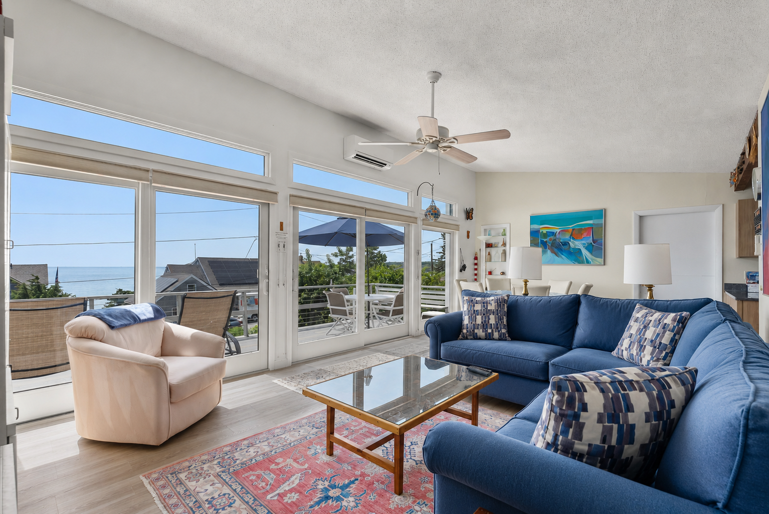 Sunlit living room with sectional sofa and ocean views.