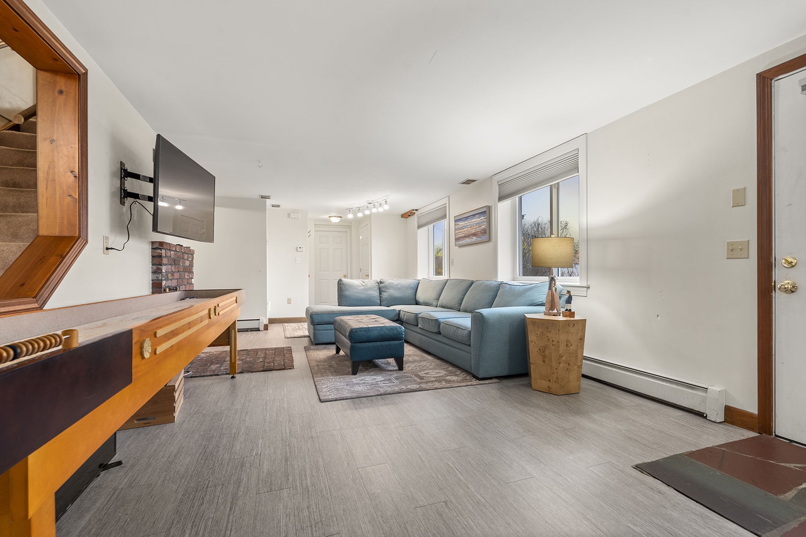 Den/Living room area with a TV and Shuffleboard in the lower floor.