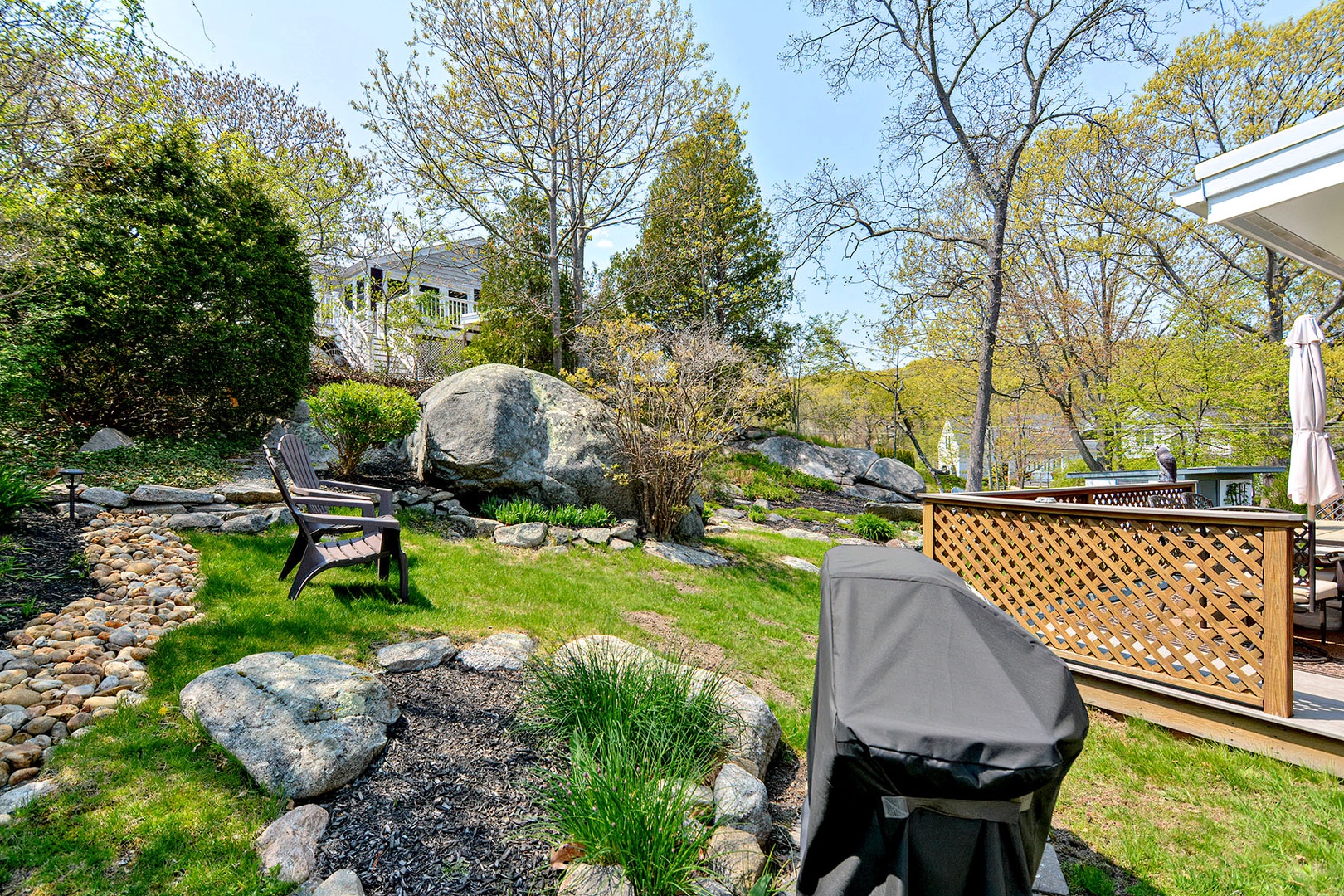 The grill area is nestled in the lush backyard.