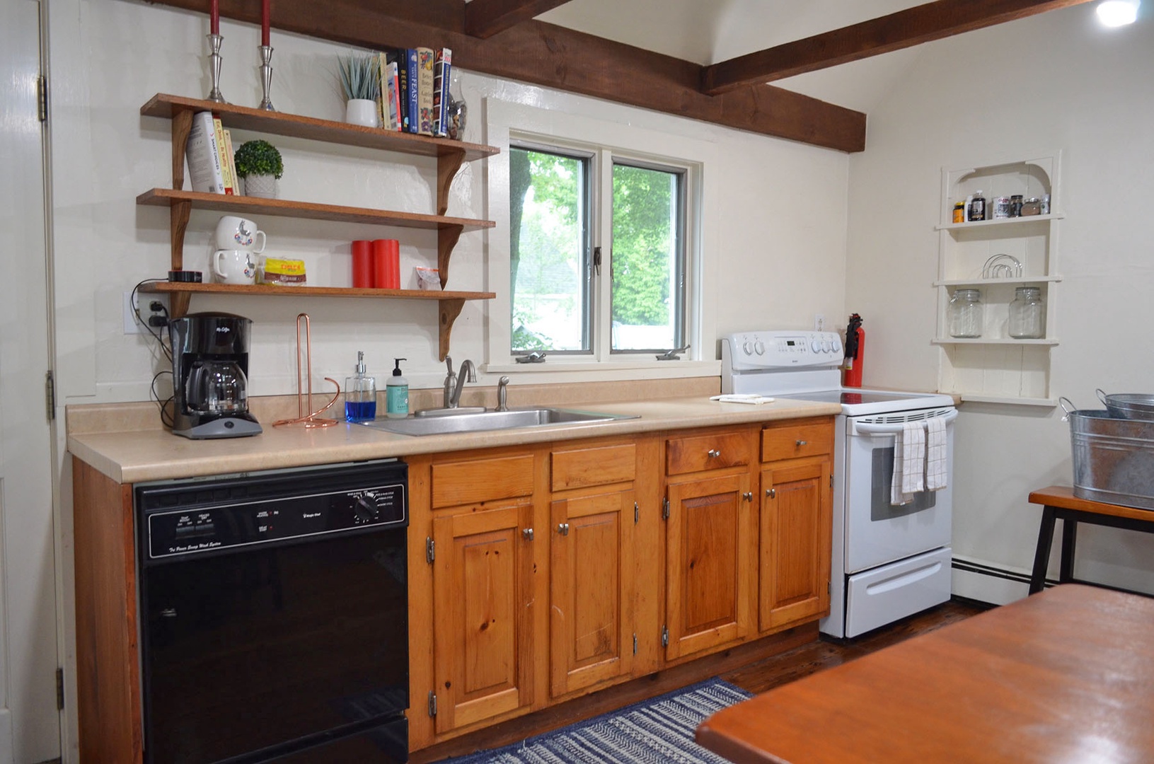The kitchen has beautiful wooden cabinetry and exposed beams. 