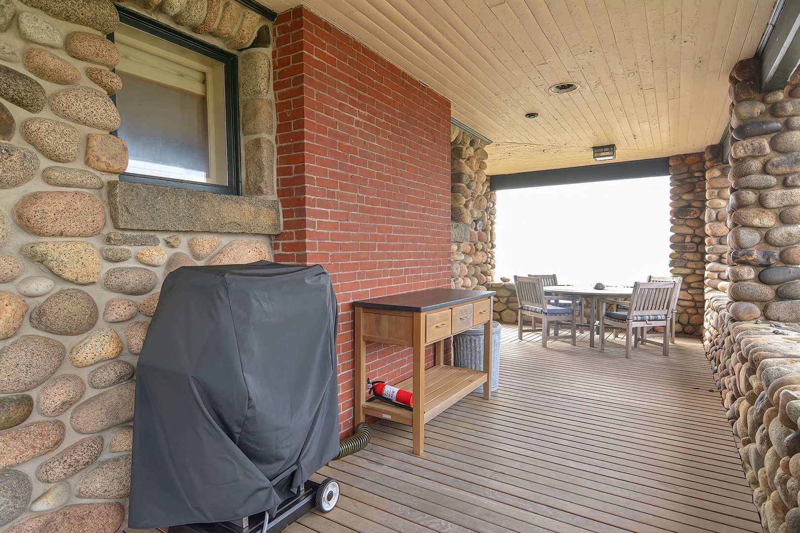 View of the wraparound porch with grill and serving island.