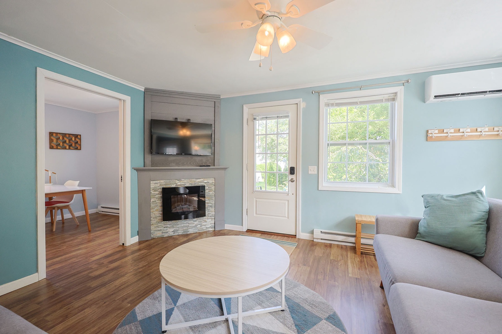 The Living Room has a large sectional sofa and a wall-mounted TV.