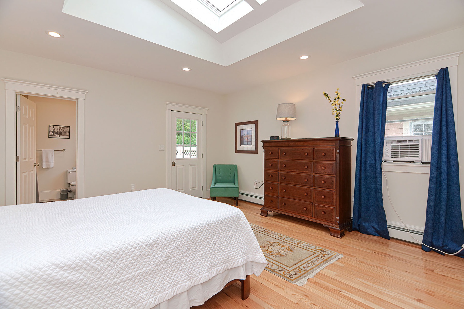 Bright room with cabinet and an arm chair inside the bedroom.