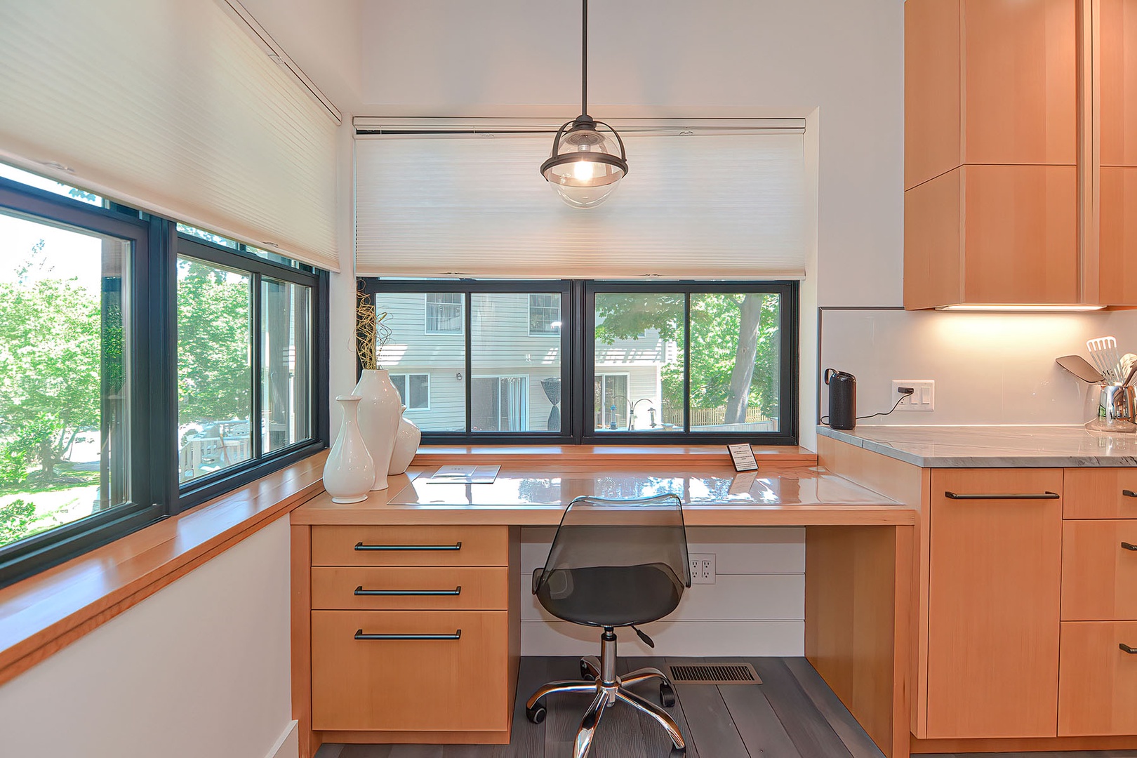 There is a corner desk under large windows, the perfect place to work from home.