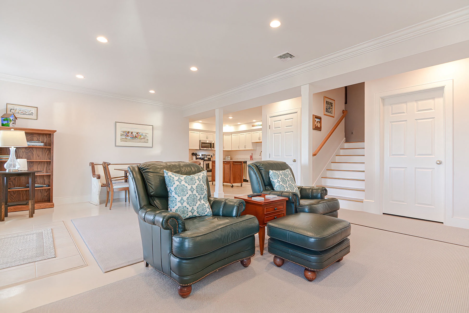 Spacious and bright living room with leather armchairs and ottomans.