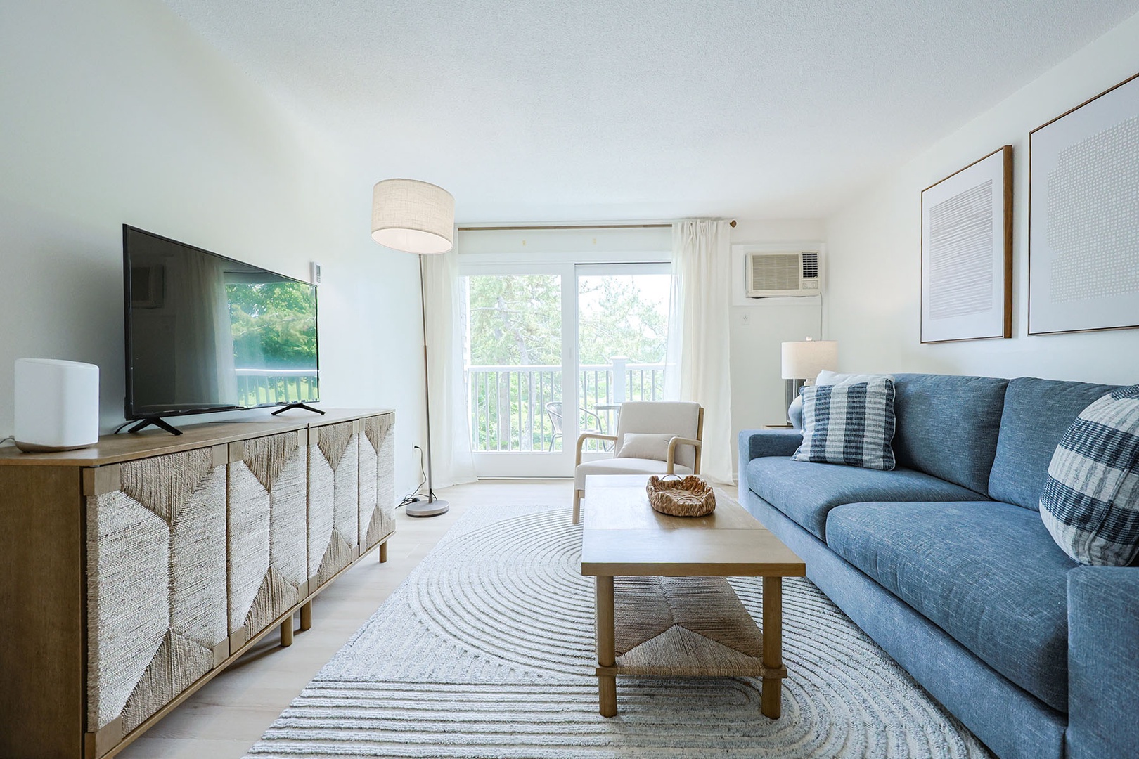 The sun-filled living room, overlooking the balcony outside.
