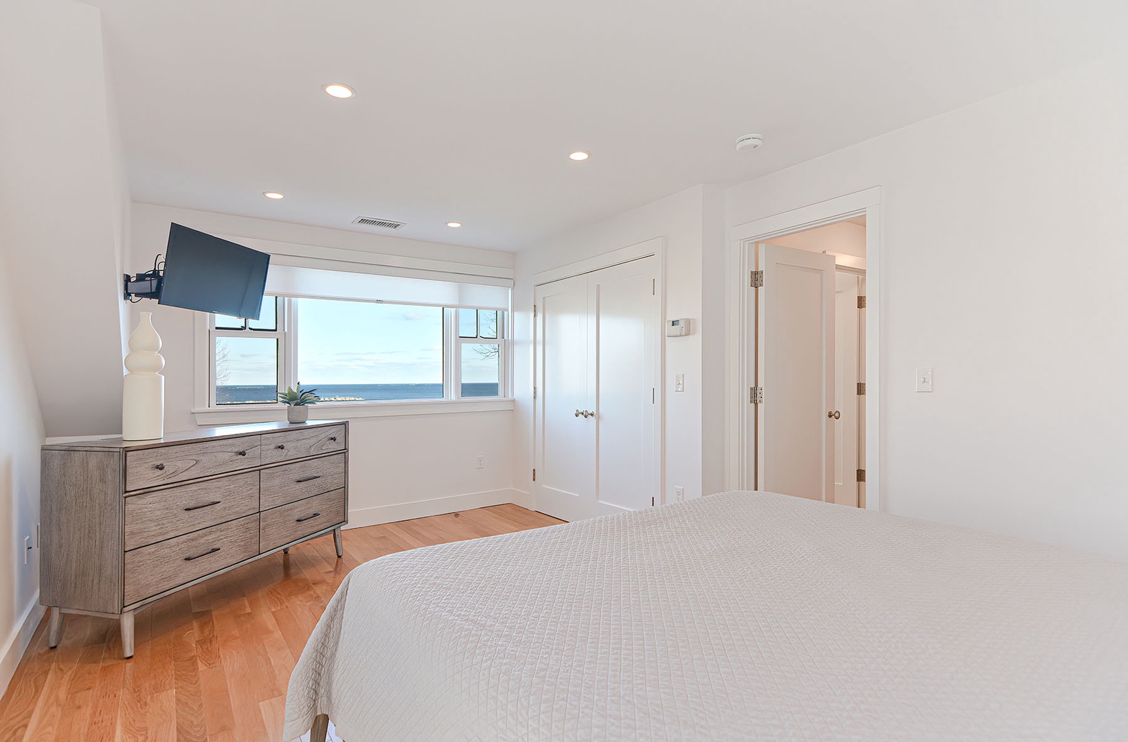 Primary bedroom with water view and TV