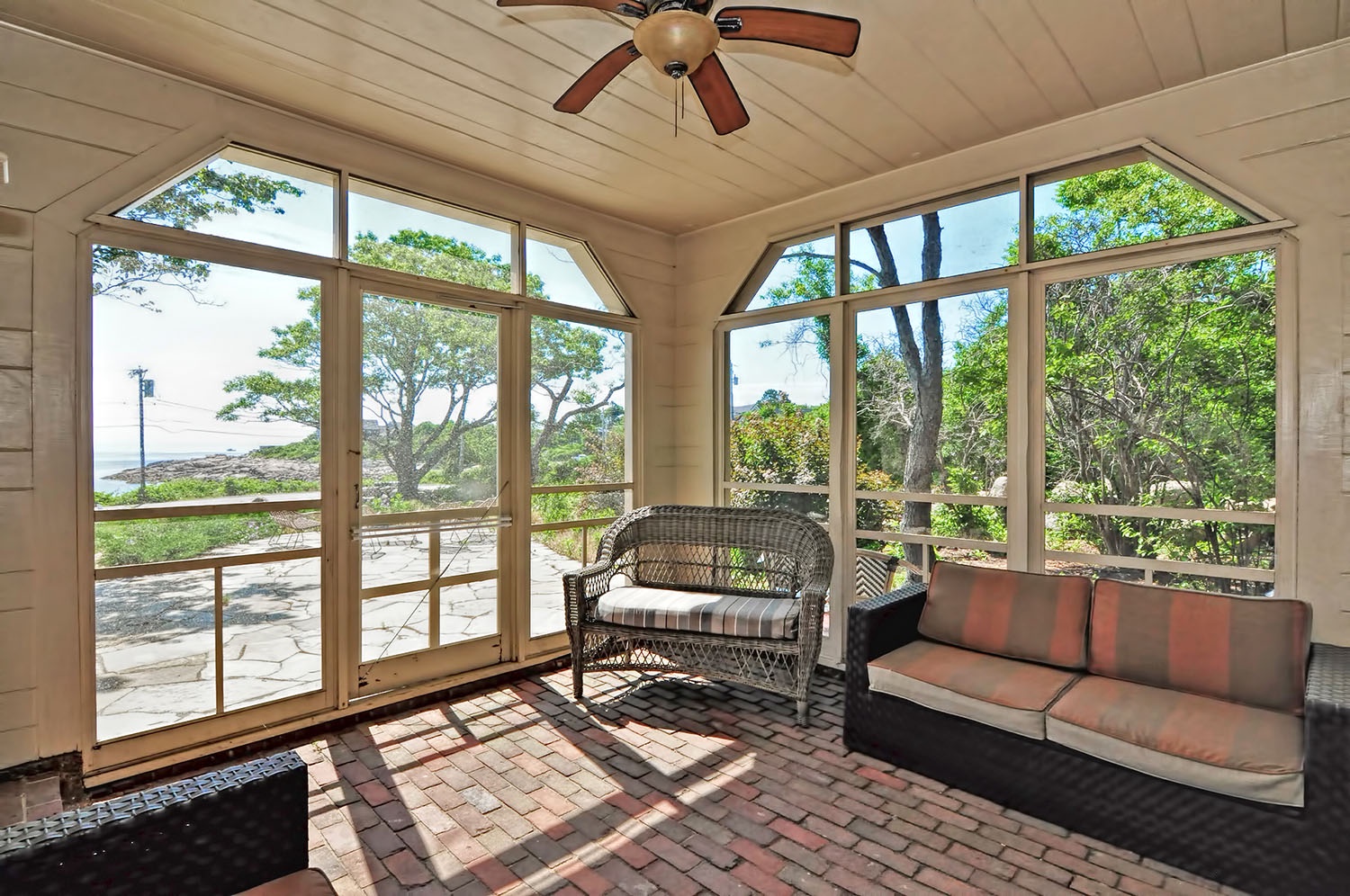 Screened porch with ocean views and ceiling fan.