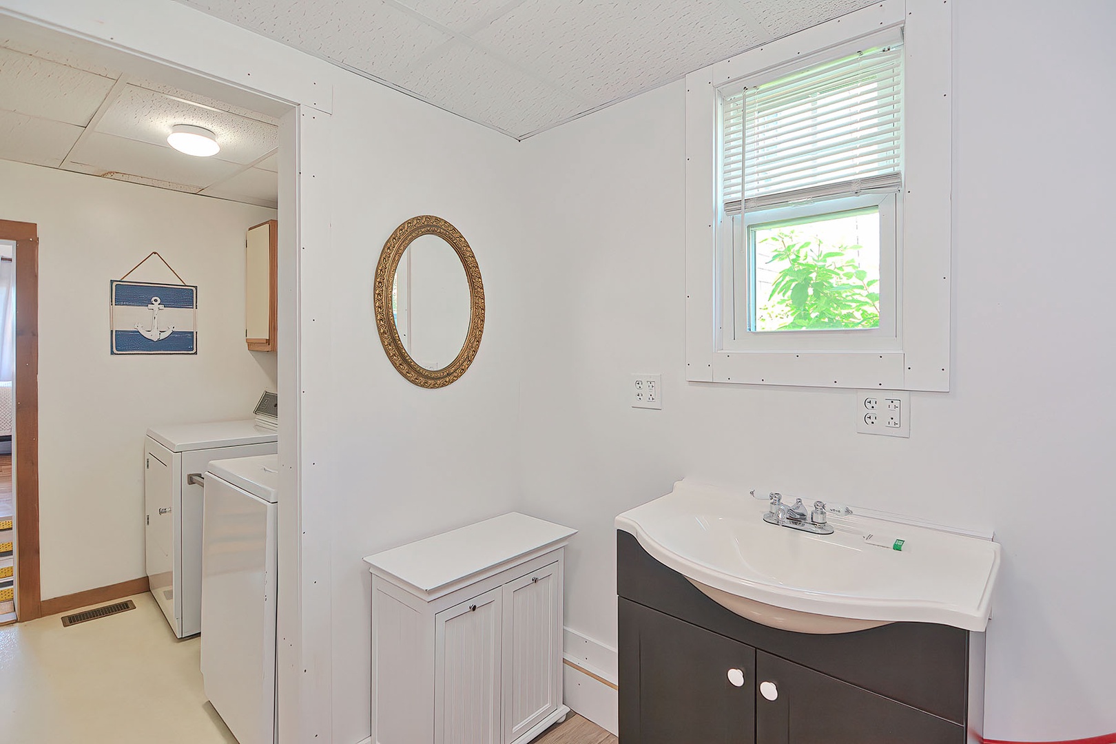 Bathroom 1: There is a bathroom beyond the laundry area, with a walk-in shower..