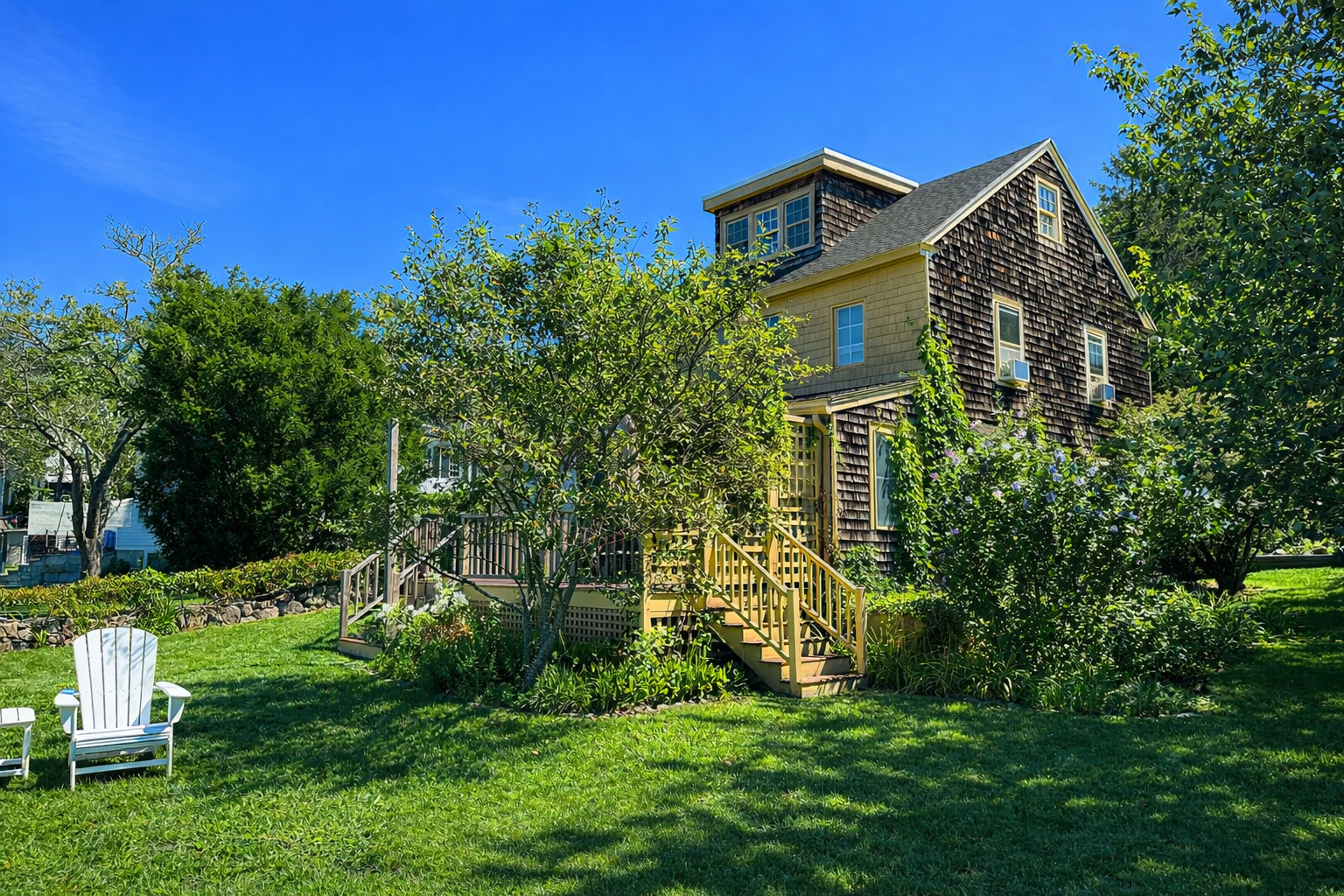 View of the back deck stairs and exterior facade of the home.