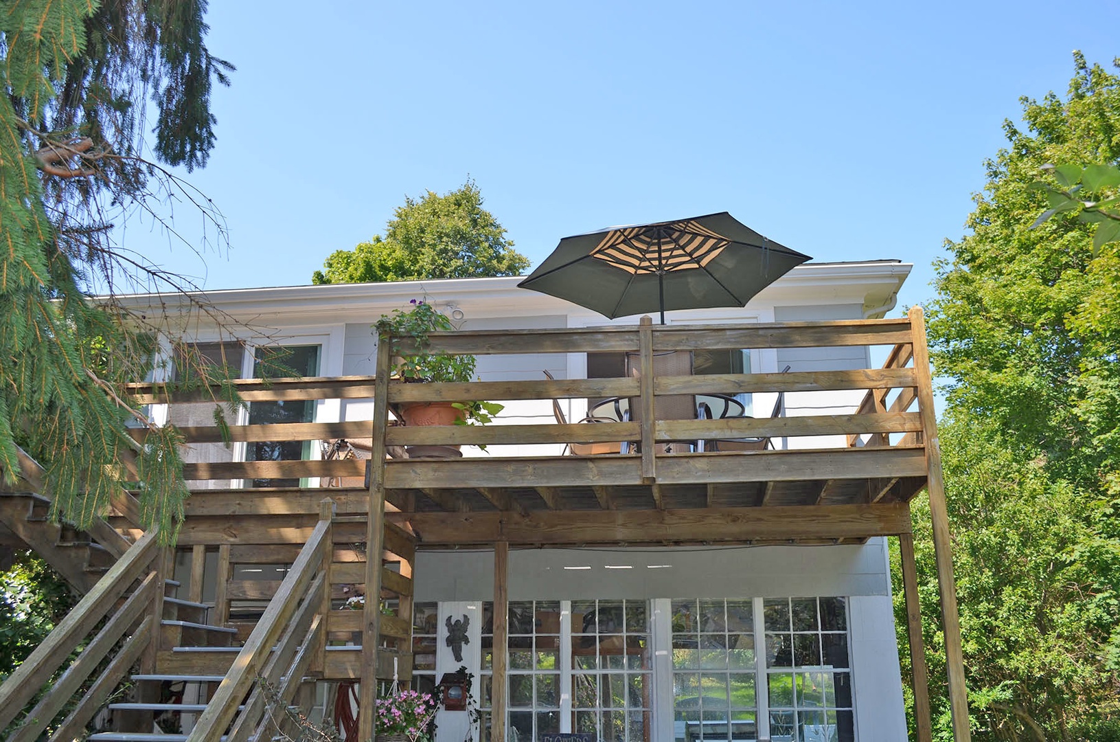 The deck has a dining table with umbrella.