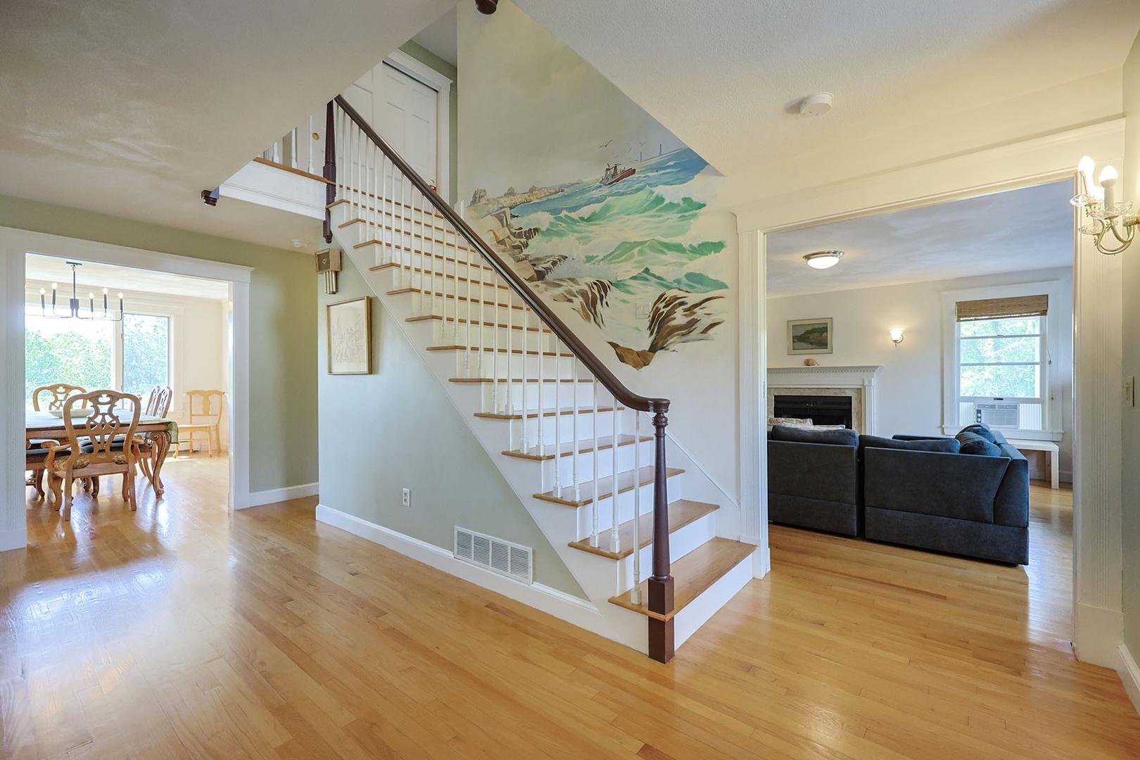 A seascape mural graces Bell View's front hall stairs.
