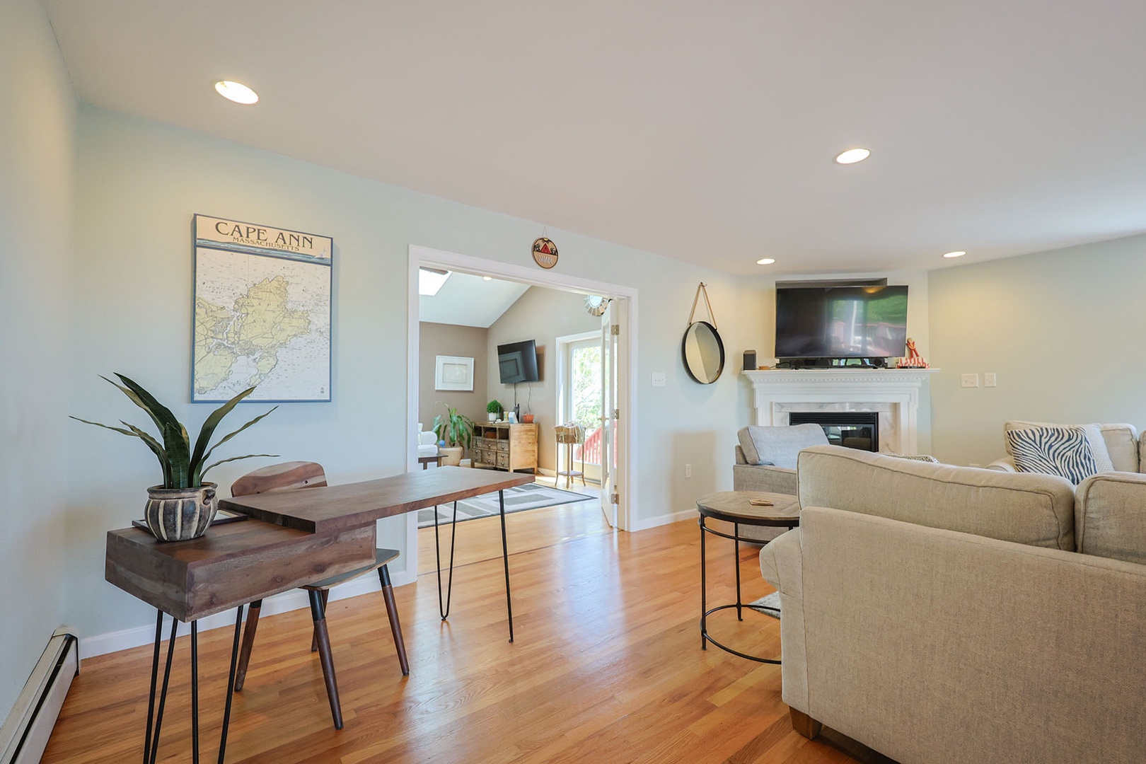 View from the living room into the den, featuring a modern wood desk to the left