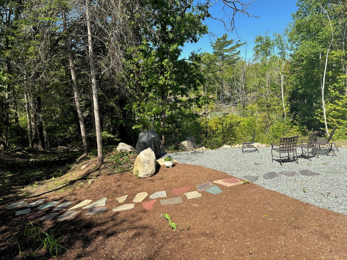 Back yard with pathway leading into the forest.